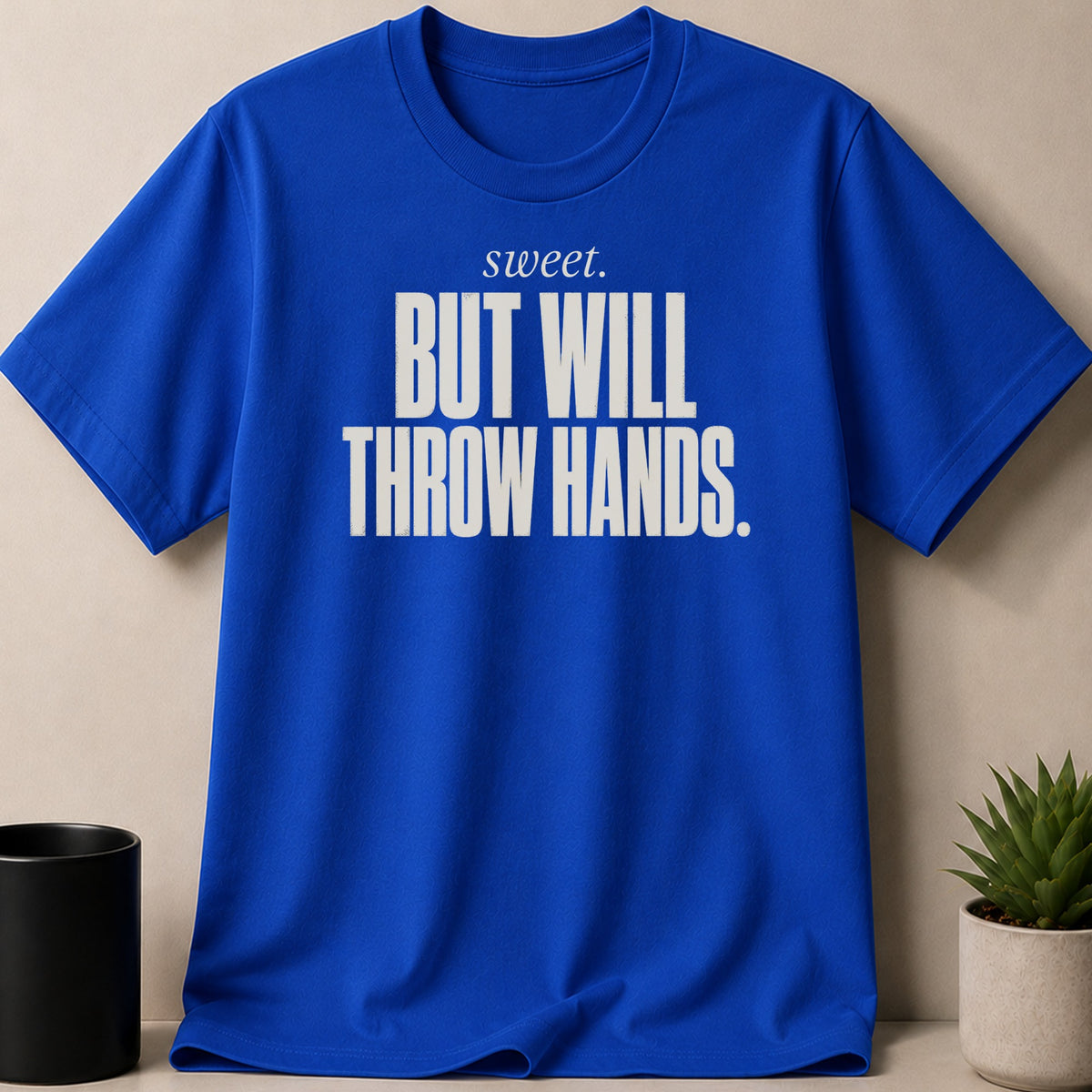 Blue t-shirt with white text "sweet. BUT WILL THROW HANDS."