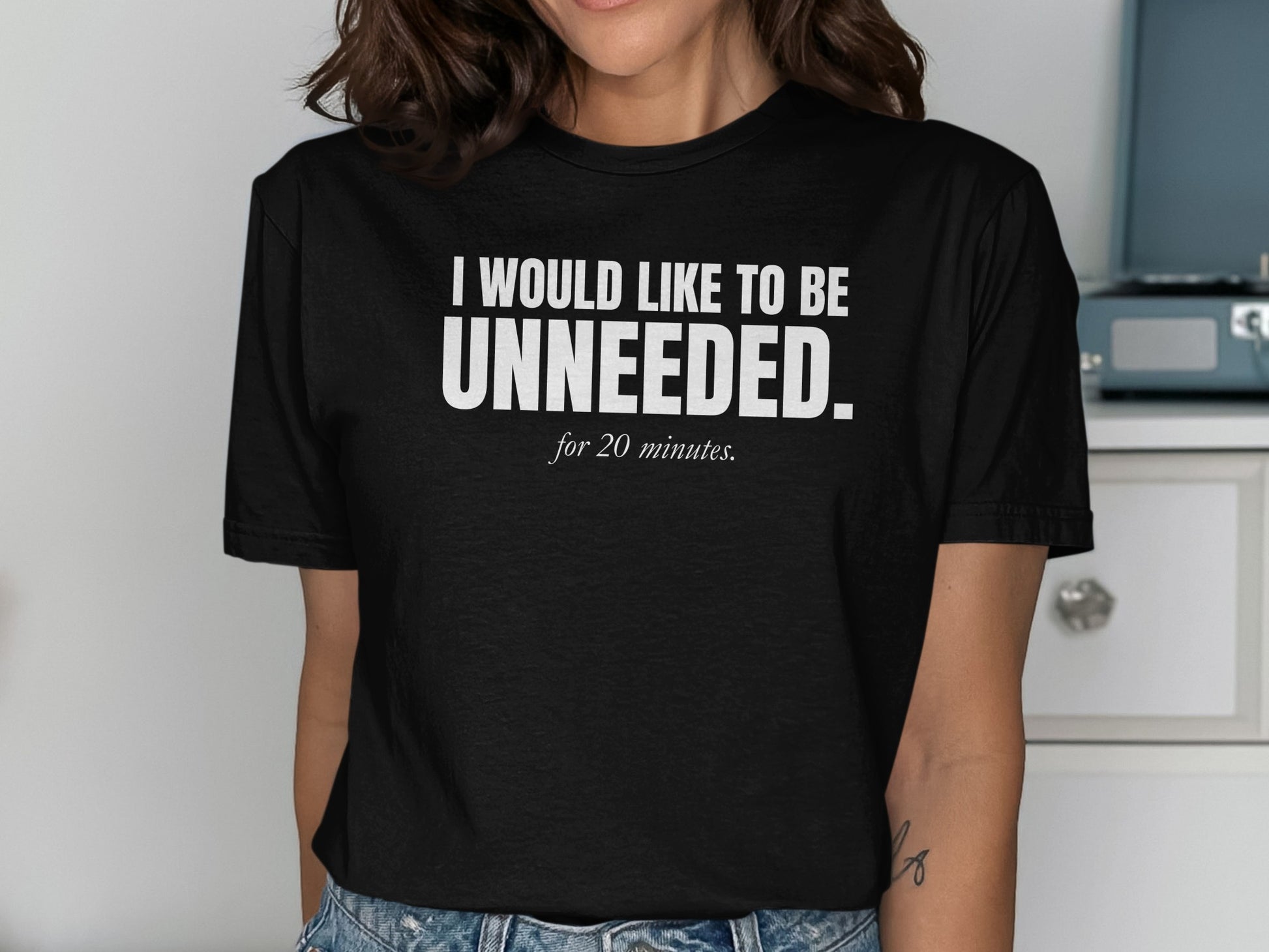 Black t-shirt with white text "I WOULD LIKE TO BE UNNEEDED. for 20 minutes."