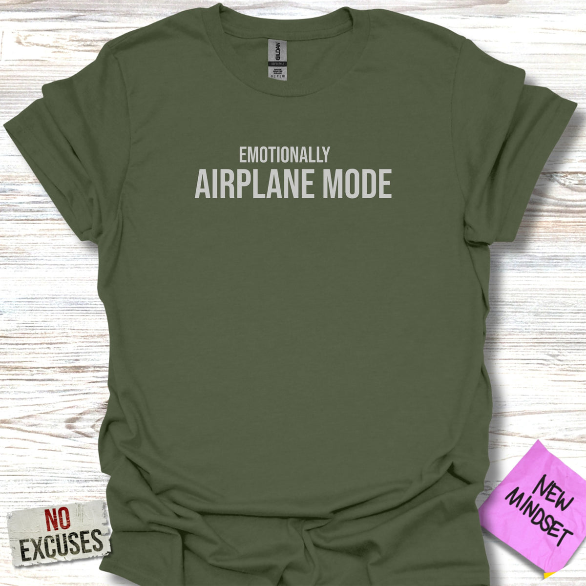 Olive green t-shirt with "Emotionally Airplane Mode" and "No Excuses" text.