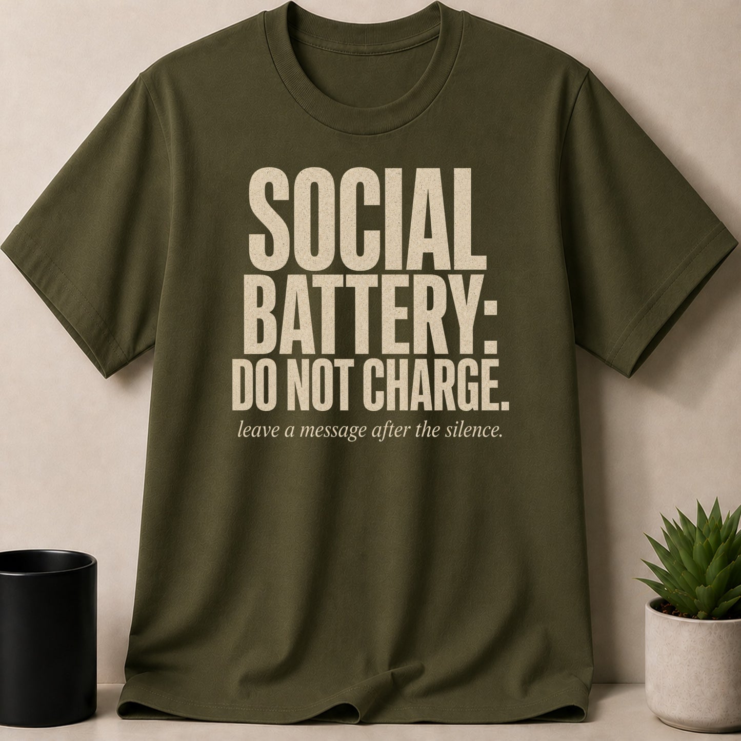 Olive green t-shirt with "SOCIAL BATTERY: DO NOT CHARGE" text.