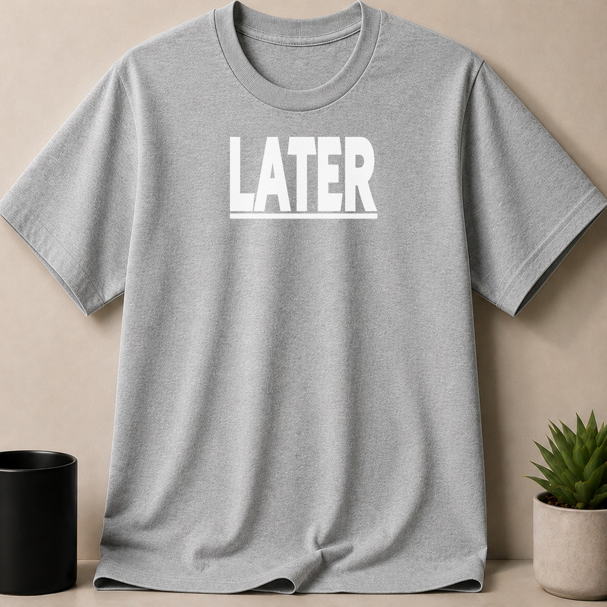 Grey t-shirt with white text "LATER" and subtle all-over pattern.