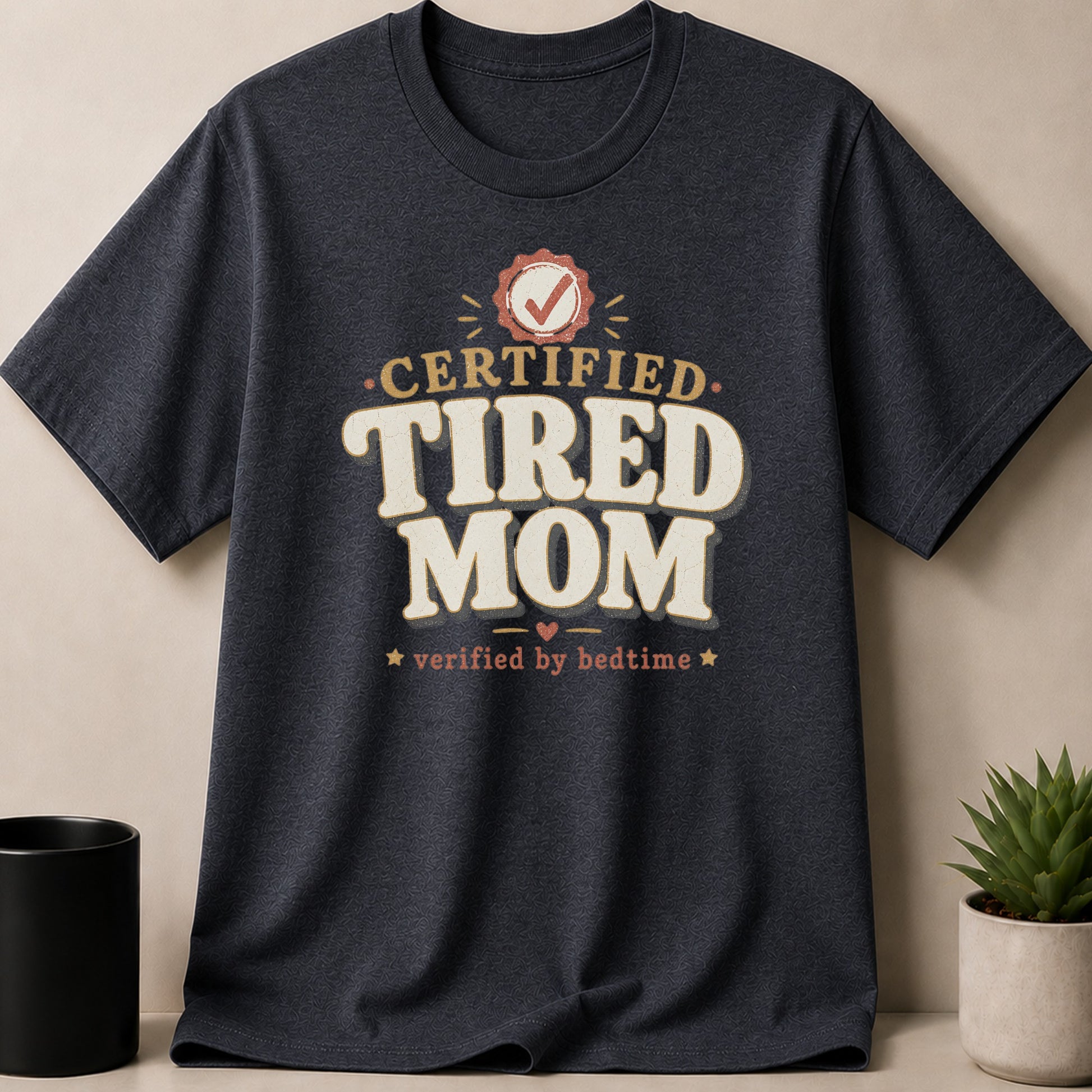Dark grey t-shirt with text "CERTIFIED TIRED MOM verified by bedtime".