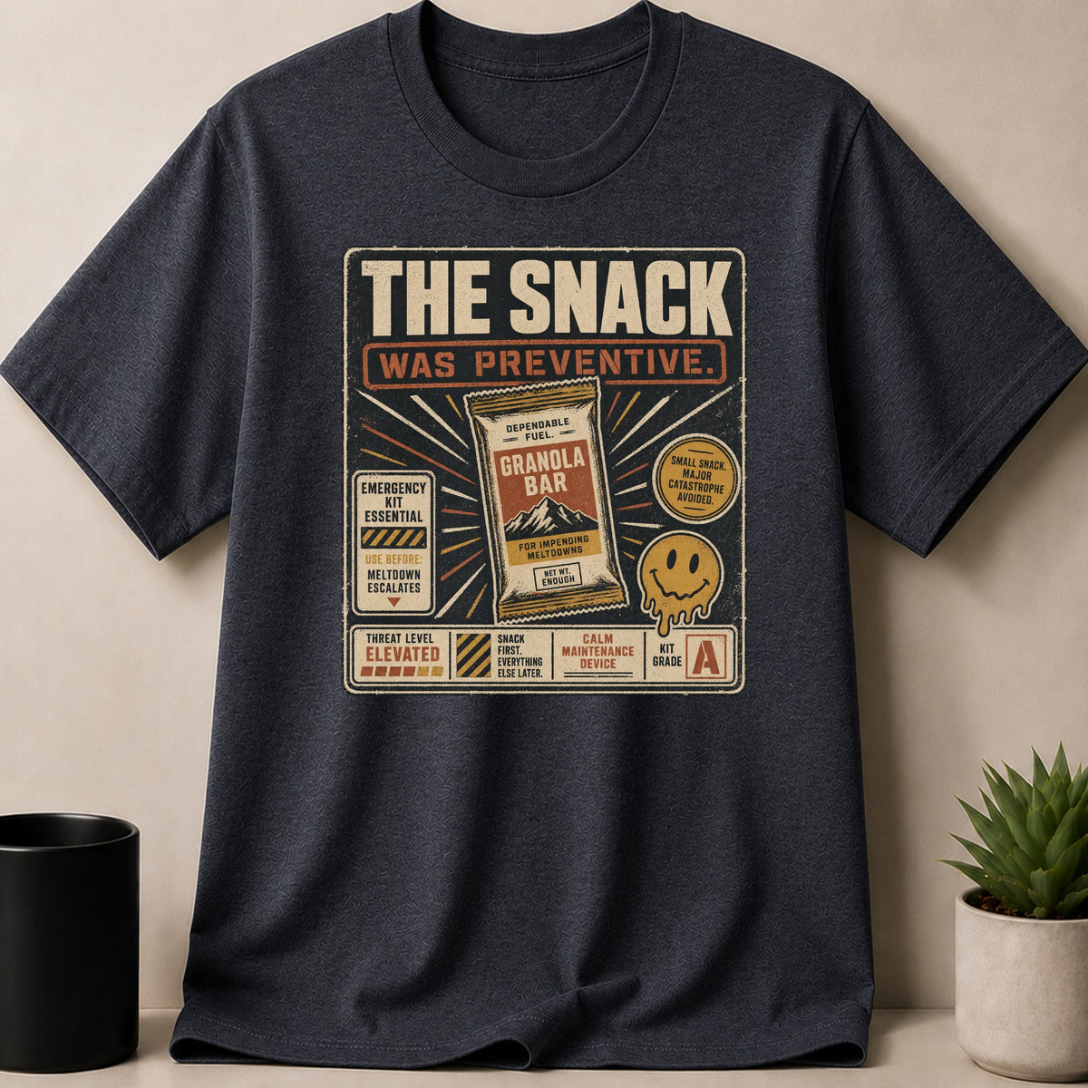 Dark t-shirt with "The Snack Was Preventive" graphic and a granola bar.