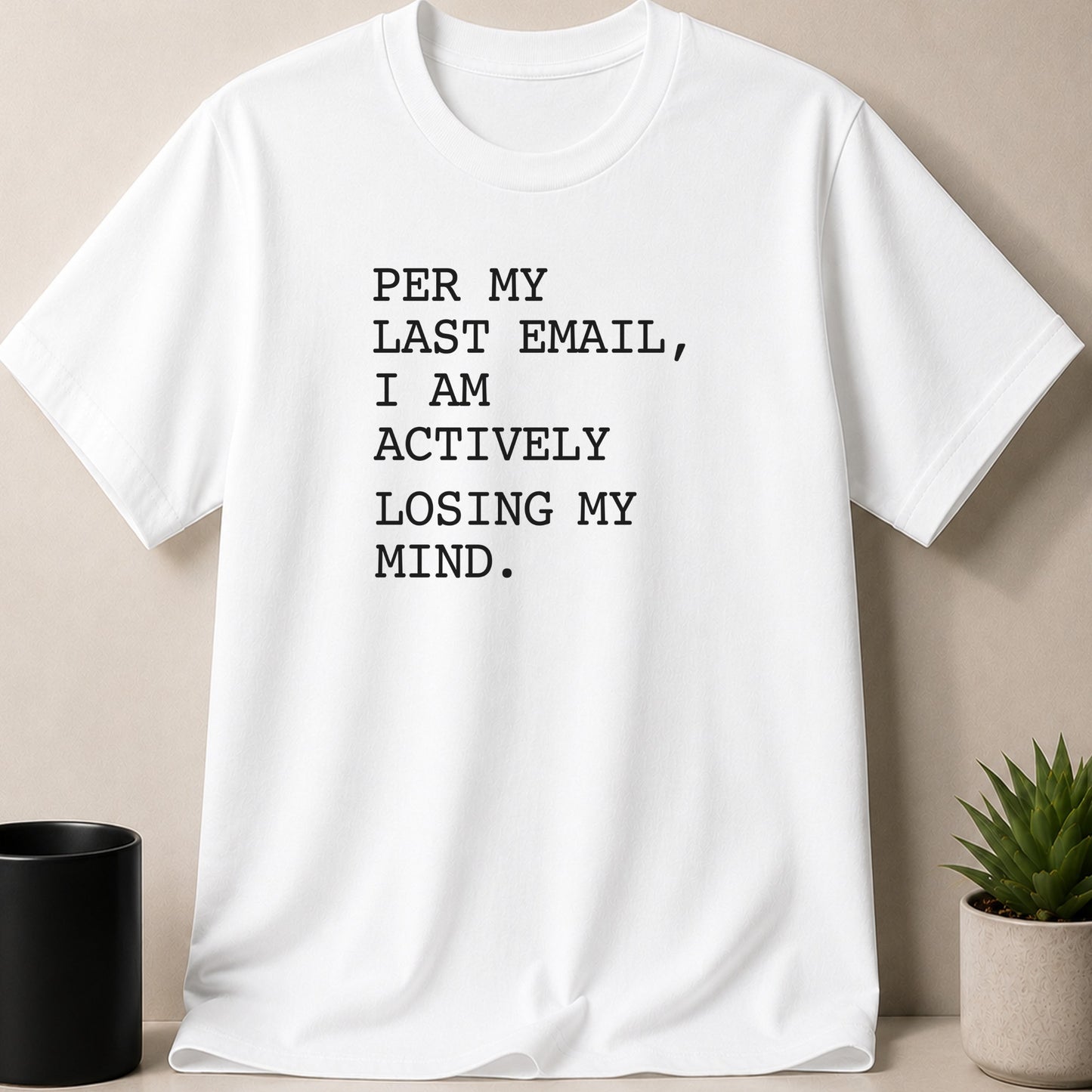 White t-shirt with black text reading "PER MY LAST EMAIL, I AM ACTIVELY LOSING MY MIND."