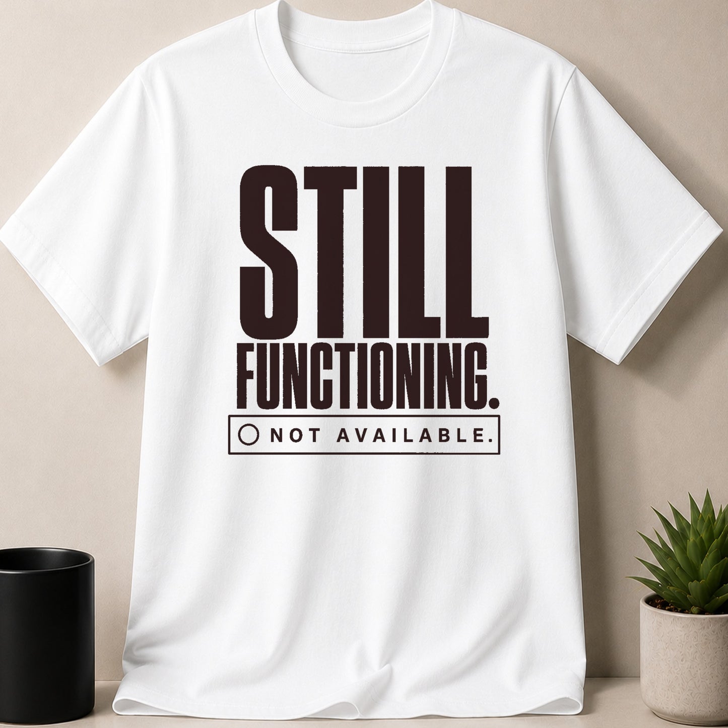 White t-shirt with "STILL FUNCTIONING. NOT AVAILABLE." text in dark brown.