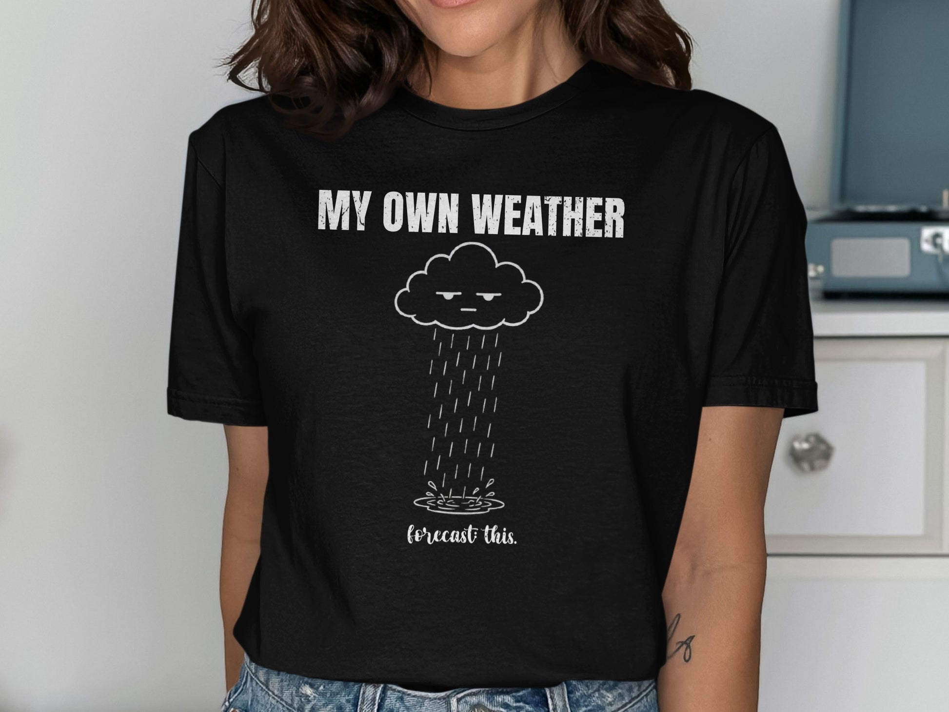 T-shirt with a grumpy cloud raining and the text "MY OWN WEATHER forecast this."