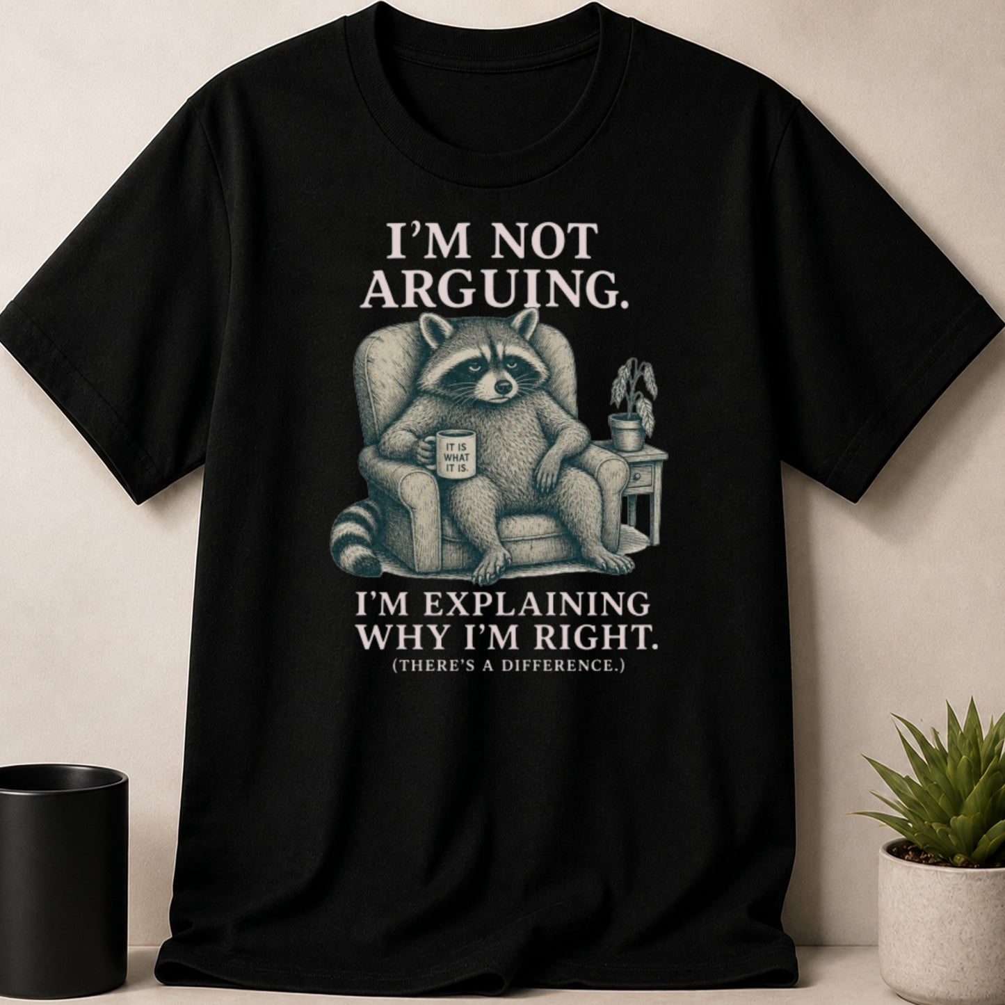 Black t-shirt with a raccoon sitting in a chair, holding a mug, with text.