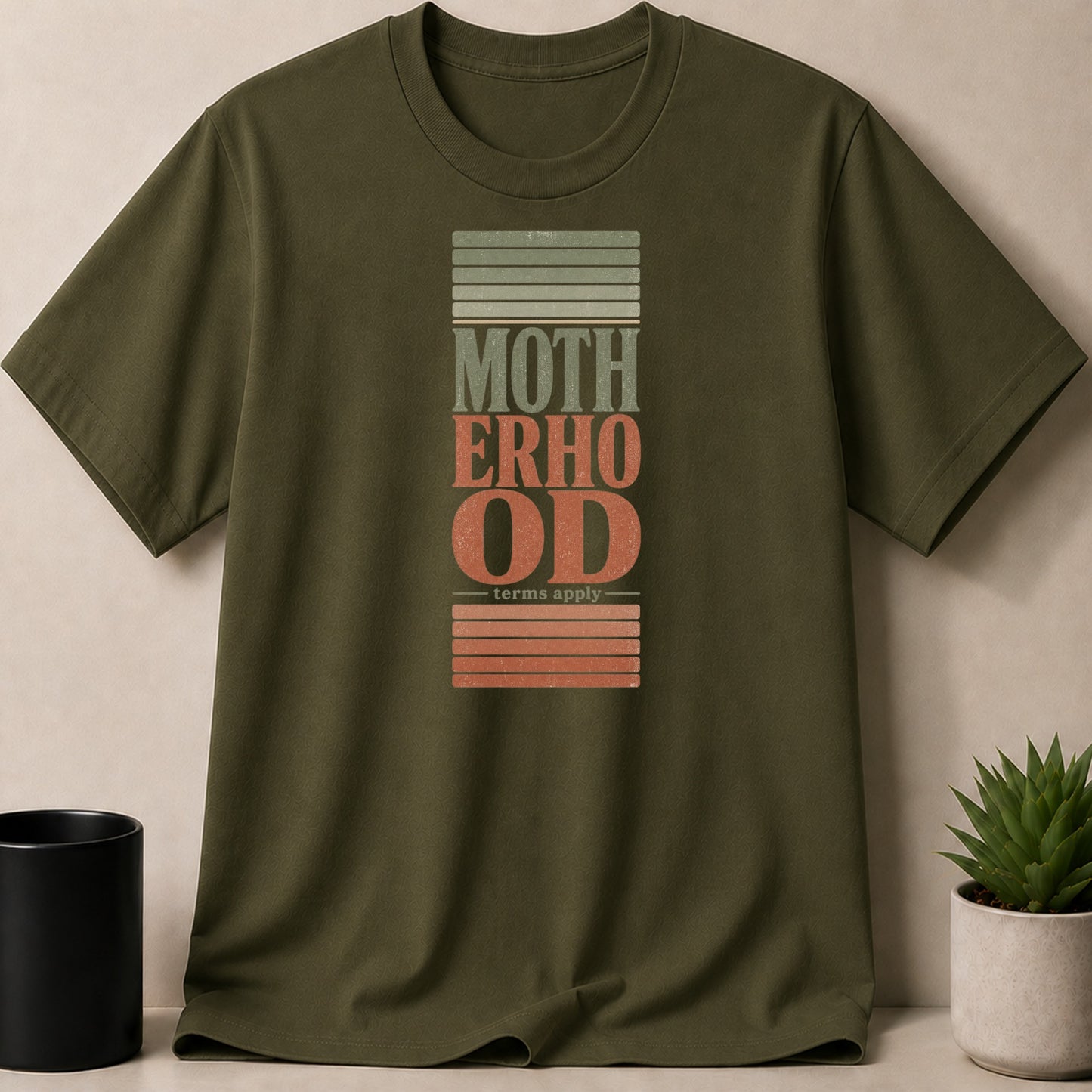 Olive t-shirt with "Motherhood terms apply" text in a distressed, vintage style.