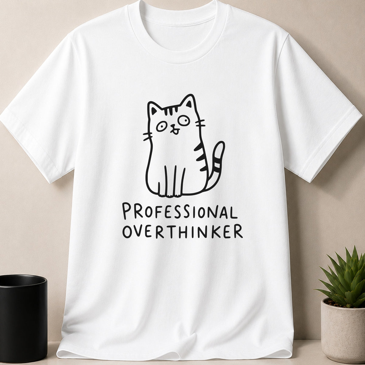 White t-shirt with cartoon cat and text "PROFESSIONAL OVERTHINKER".