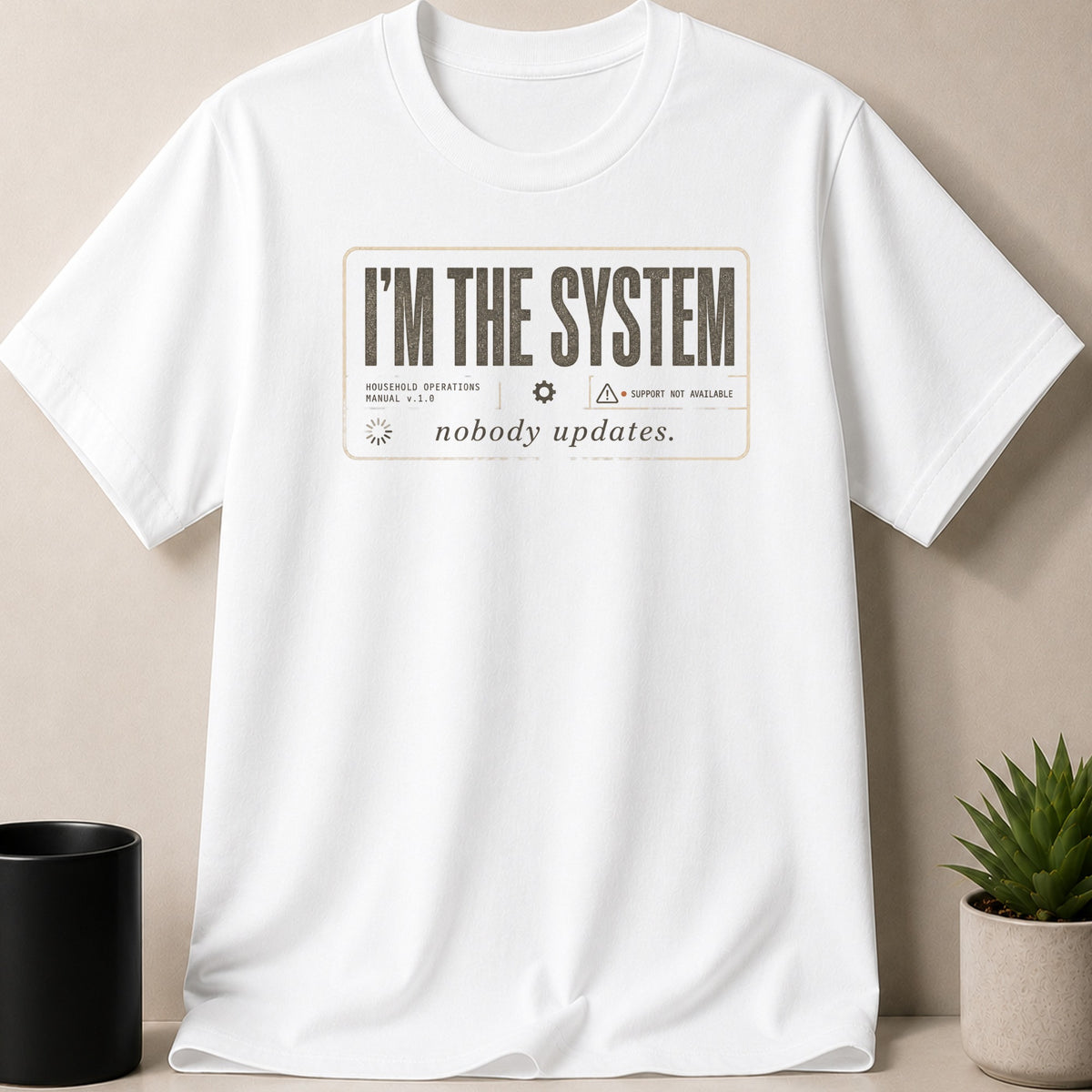 White t-shirt with "I'M THE SYSTEM, nobody updates." text on the front.