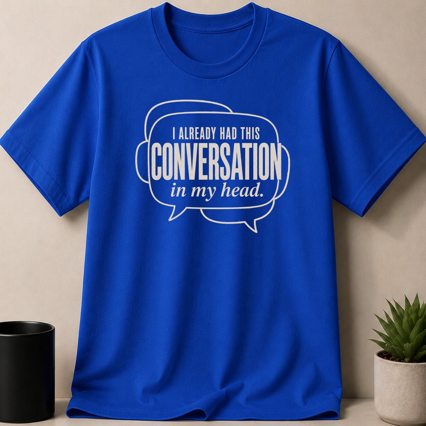 Blue t-shirt with white text "I ALREADY HAD THIS CONVERSATION in my head."