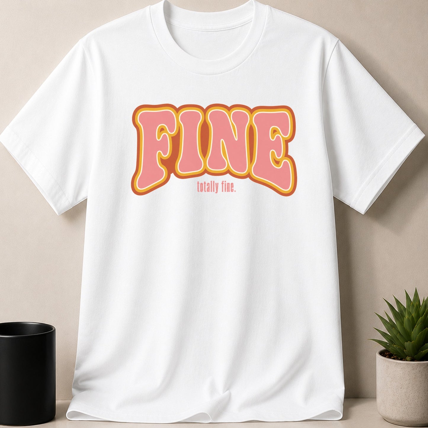 White t-shirt with "FINE totally fine." graphic in pink and orange retro font.