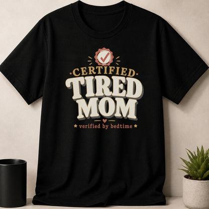 Black t-shirt with "CERTIFIED TIRED MOM verified by bedtime" text and checkmark badge.
