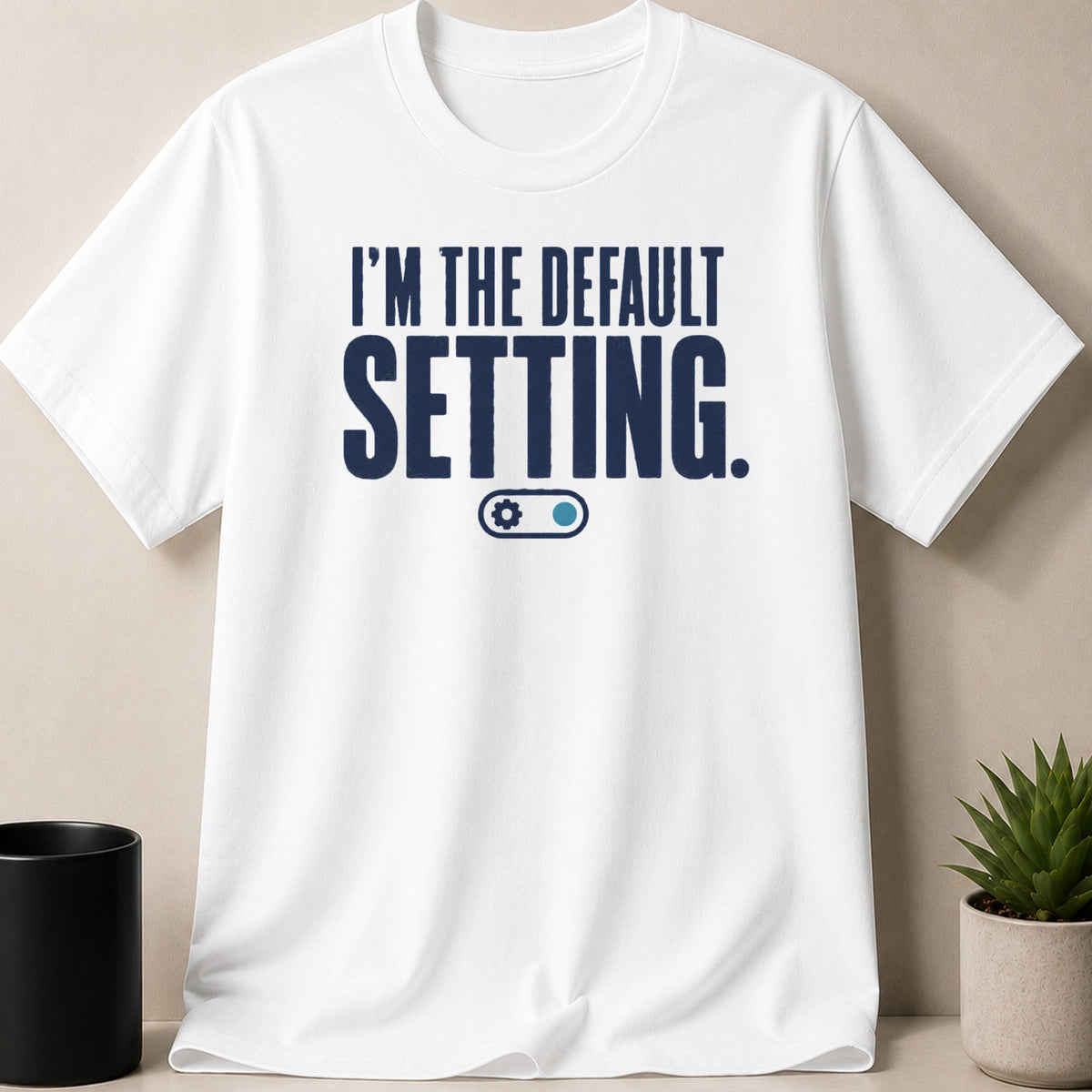 White t-shirt with navy blue text "I'M THE DEFAULT SETTING." and a toggle graphic.