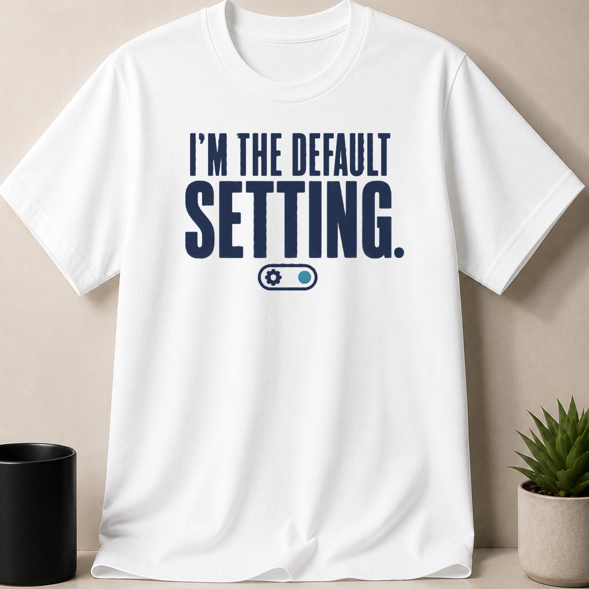 White t-shirt with navy blue text "I'M THE DEFAULT SETTING." and a toggle graphic.