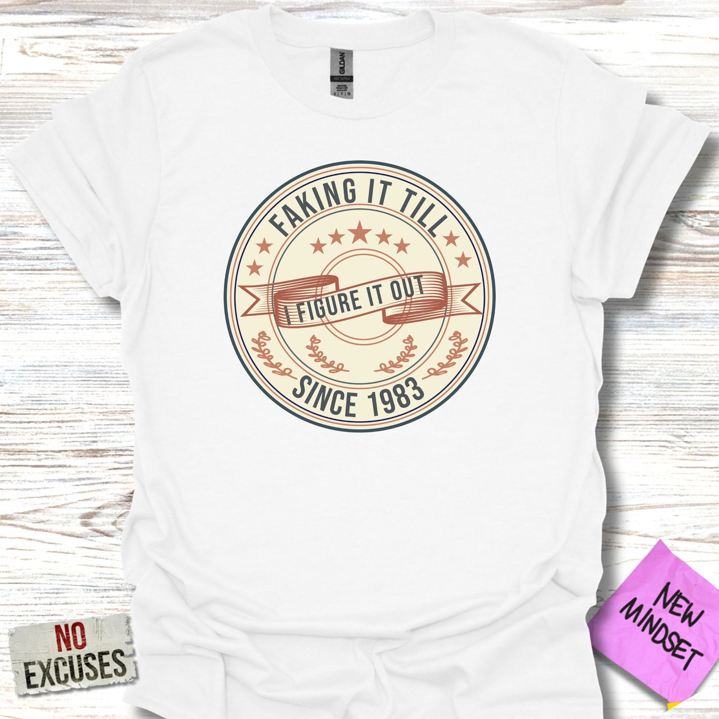 White t-shirt with "Faking It Till I Figure It Out Since 1983" graphic.