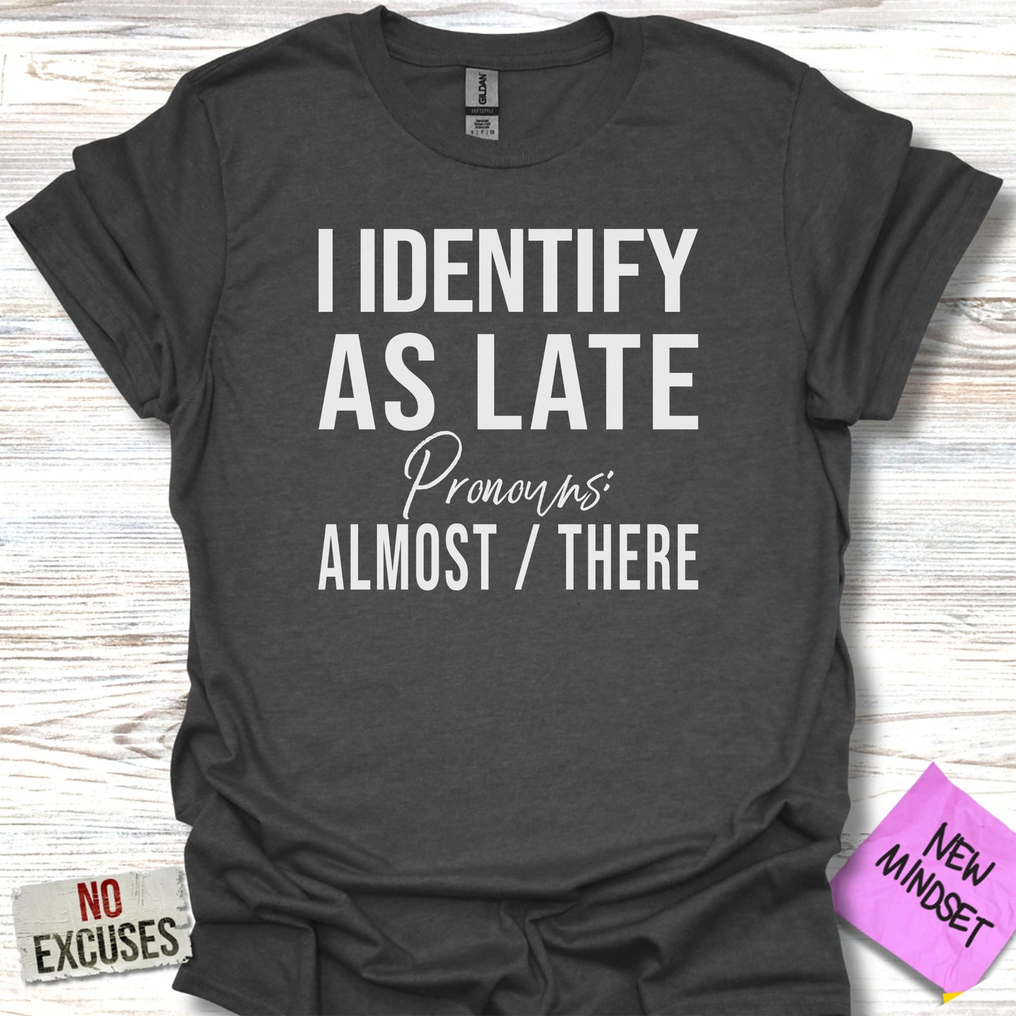 Dark grey t-shirt with "I IDENTIFY AS LATE" and "ALMOST / THERE" text.