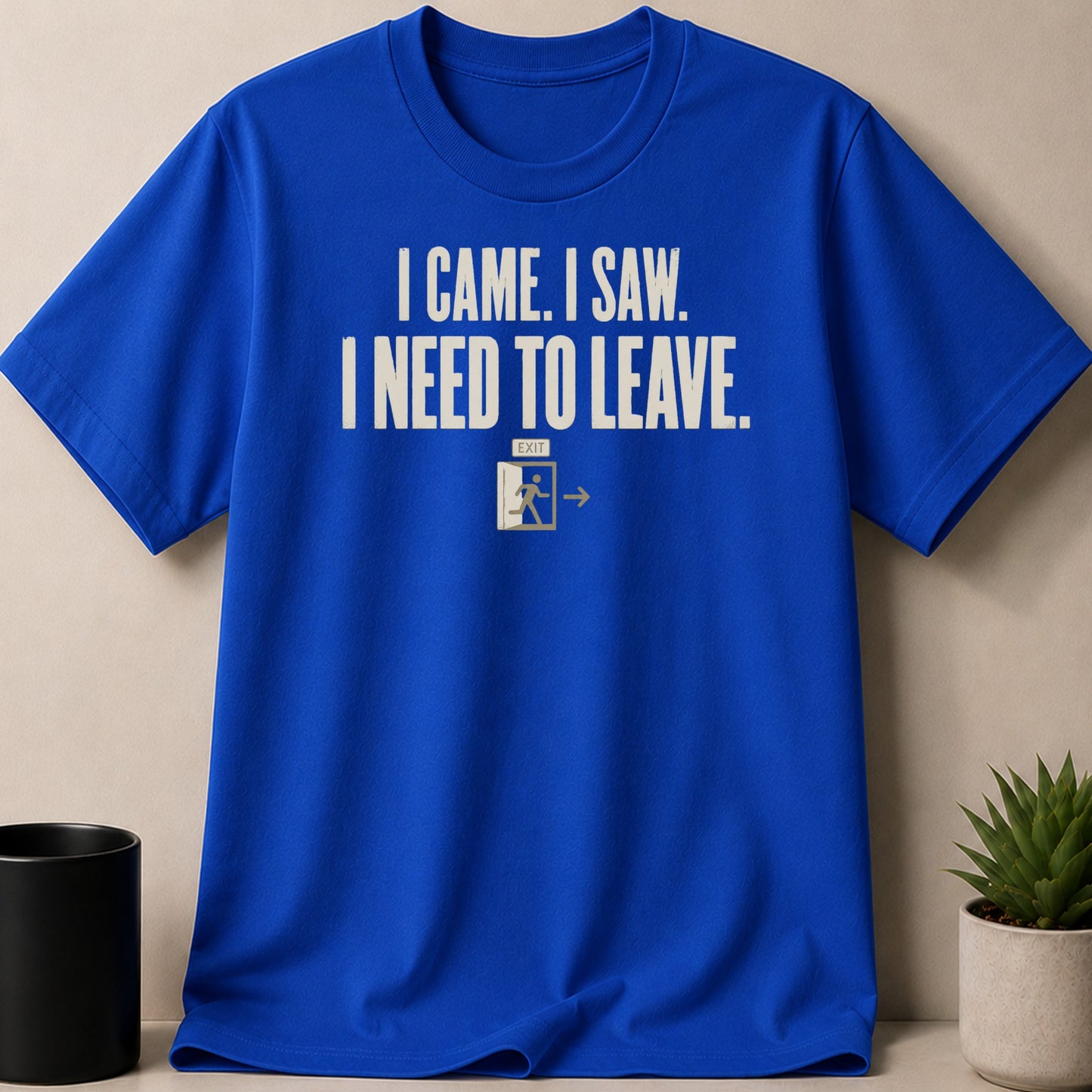 Blue t-shirt with distressed cream text "I CAME. I SAW. I NEED TO LEAVE." and an exit sign.