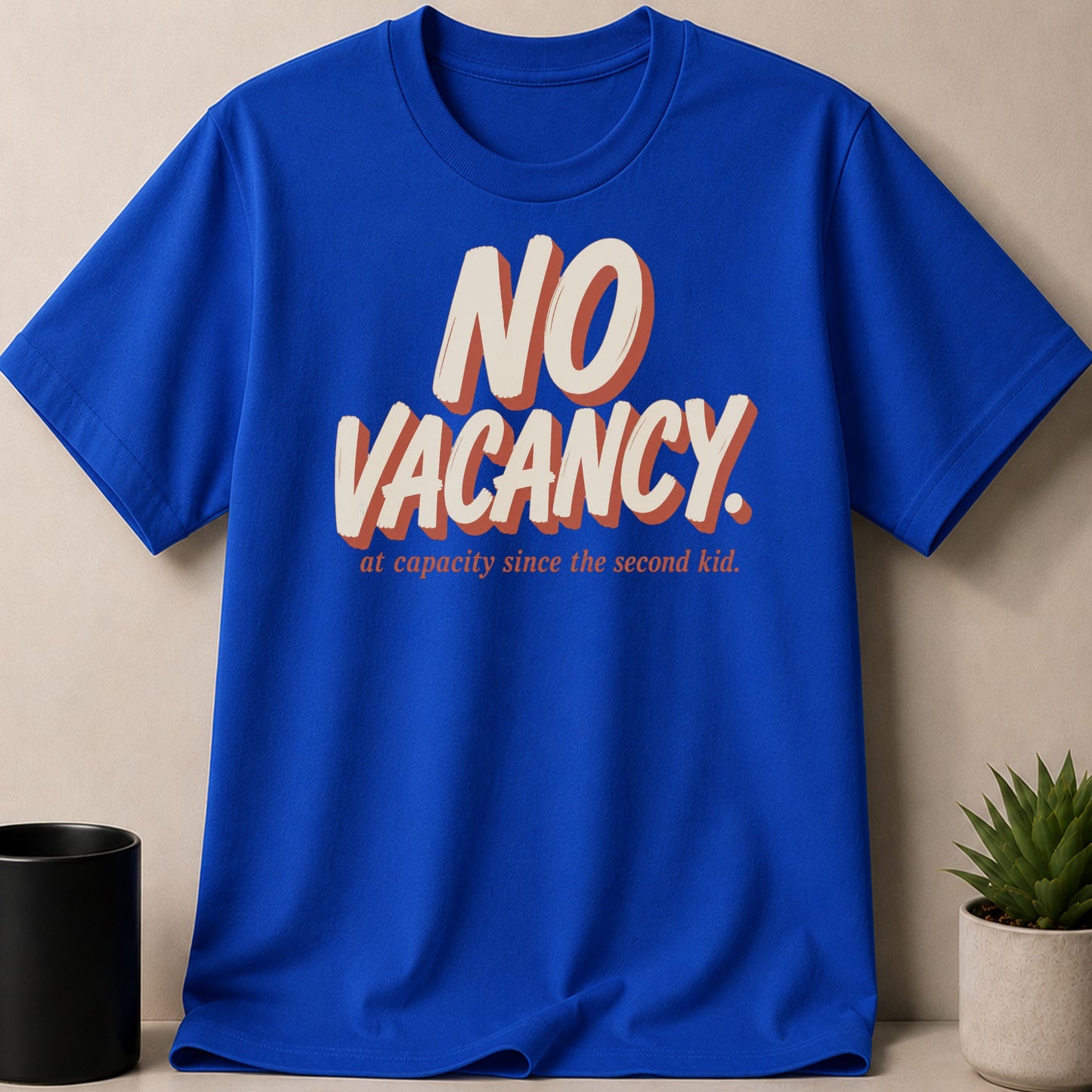 Blue t-shirt with "NO VACANCY" and "at capacity since the second kid." text.