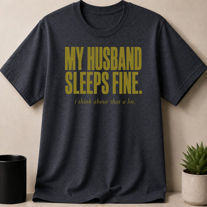 Dark grey t-shirt with text "MY HUSBAND SLEEPS FINE. i think about that a lot."