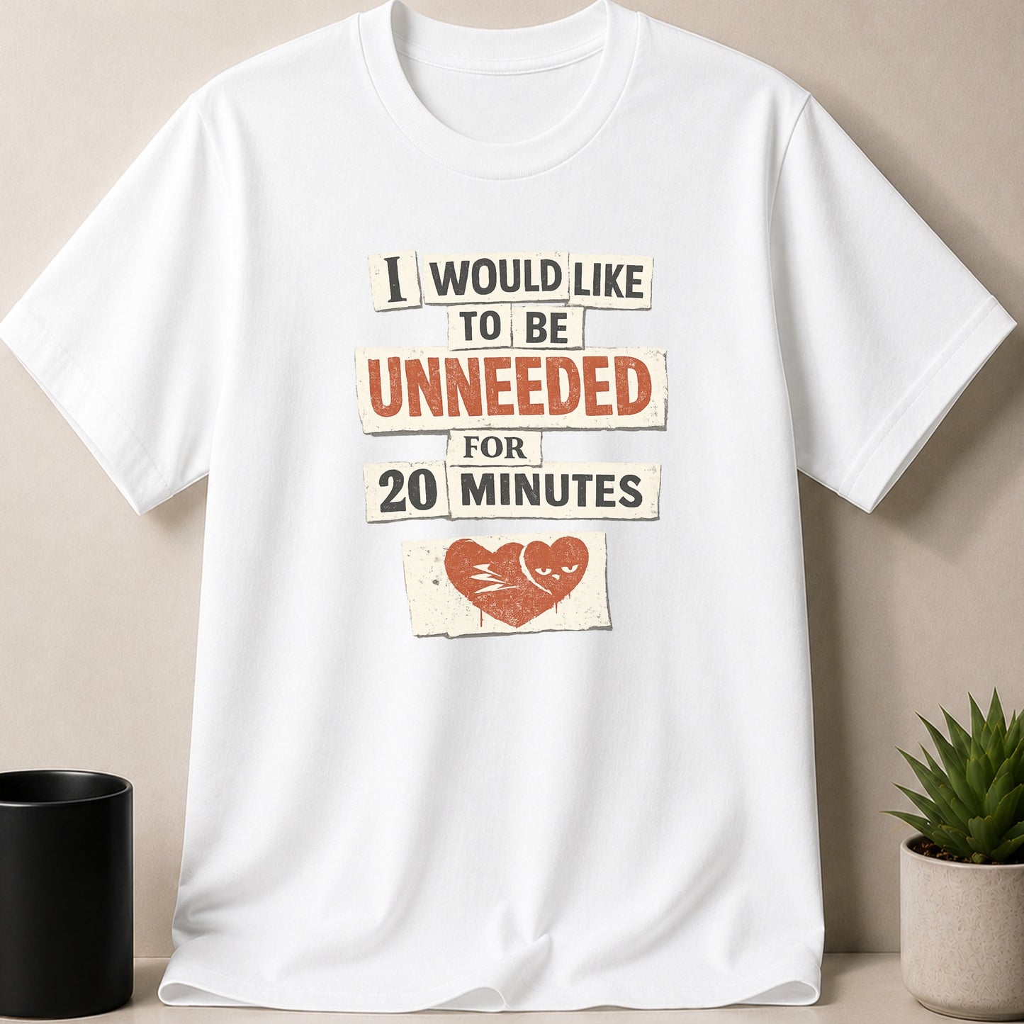 White t-shirt with text "I would like to be unneeded for 20 minutes" and a broken heart graphic.