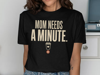 Black t-shirt with "MOM NEEDS A MINUTE." text and a coffee cup icon.