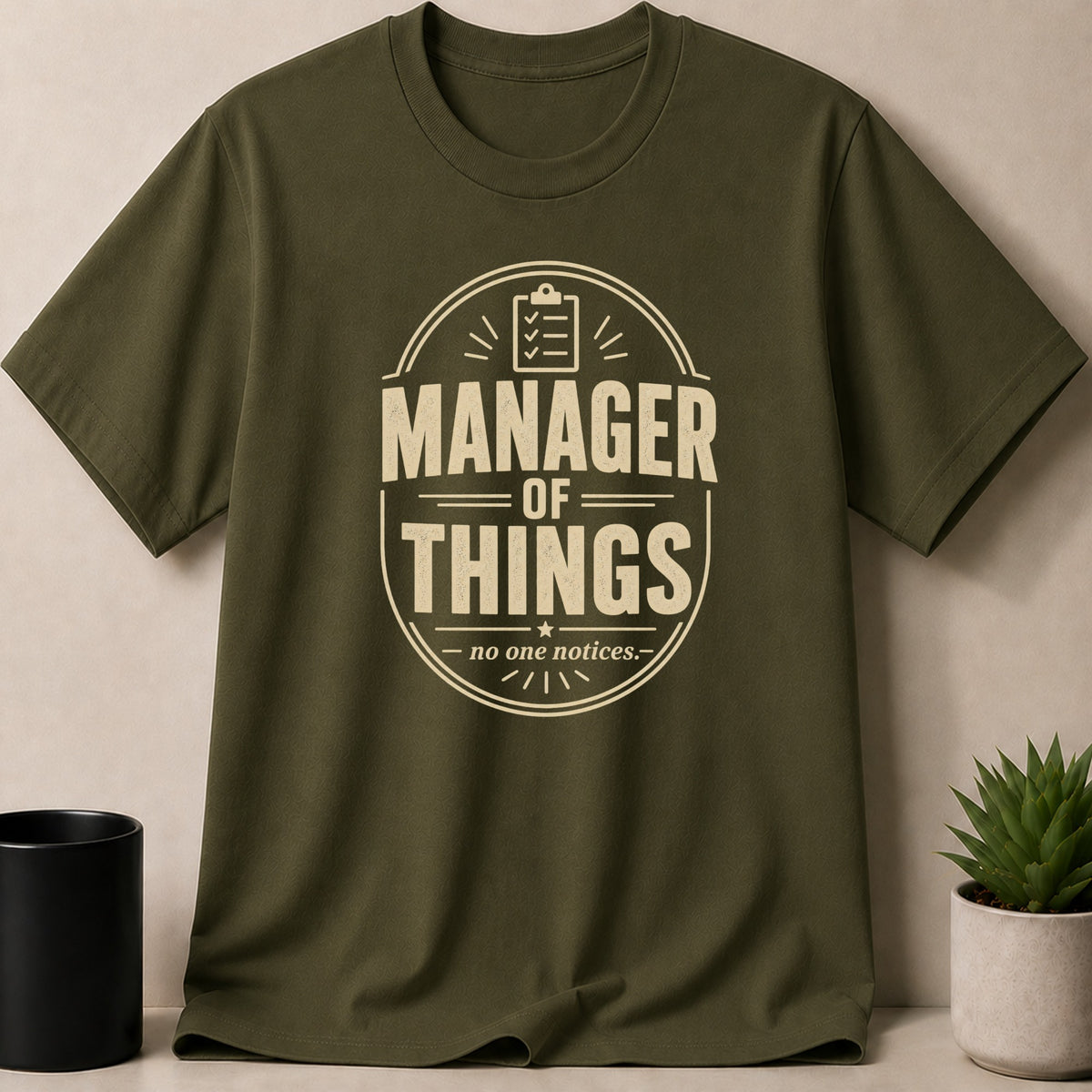Olive green t-shirt with "Manager of Things - no one notices." text.