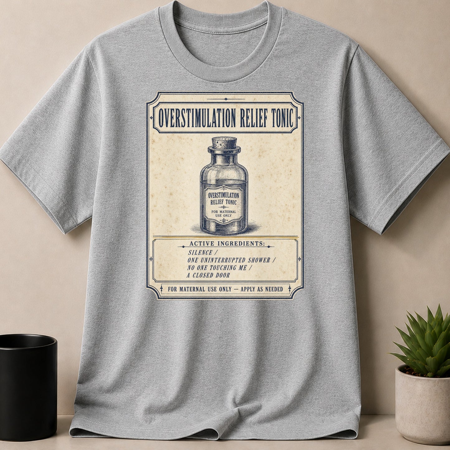 Gray t-shirt with "Overstimulation Relief Tonic" design featuring a bottle and ingredients.