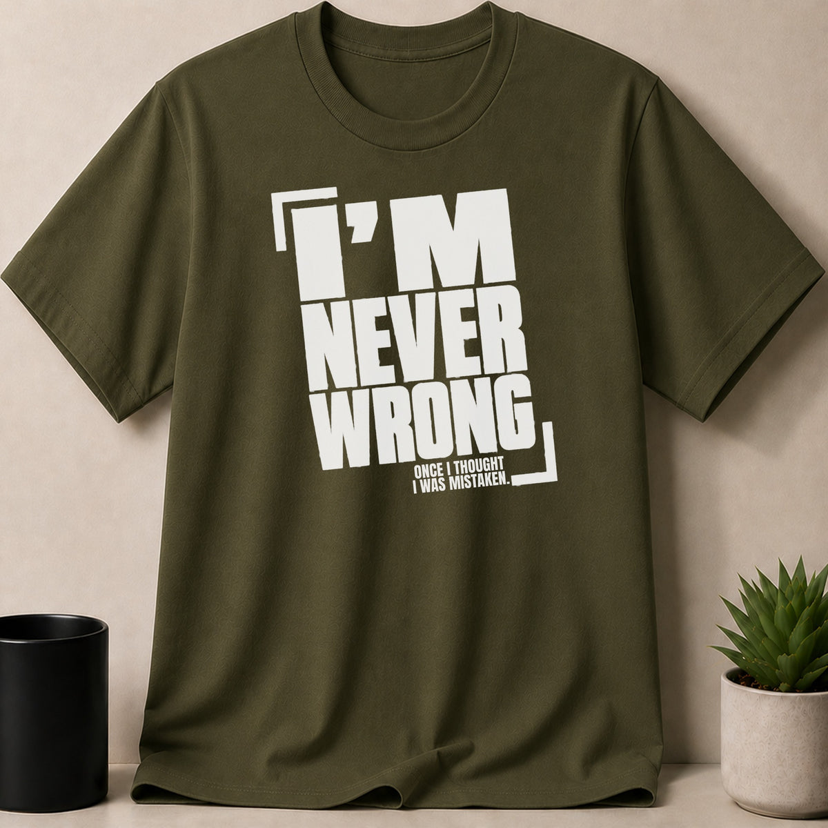 Olive green t-shirt with white text: "I'M NEVER WRONG. ONCE I THOUGHT I WAS MISTAKEN."