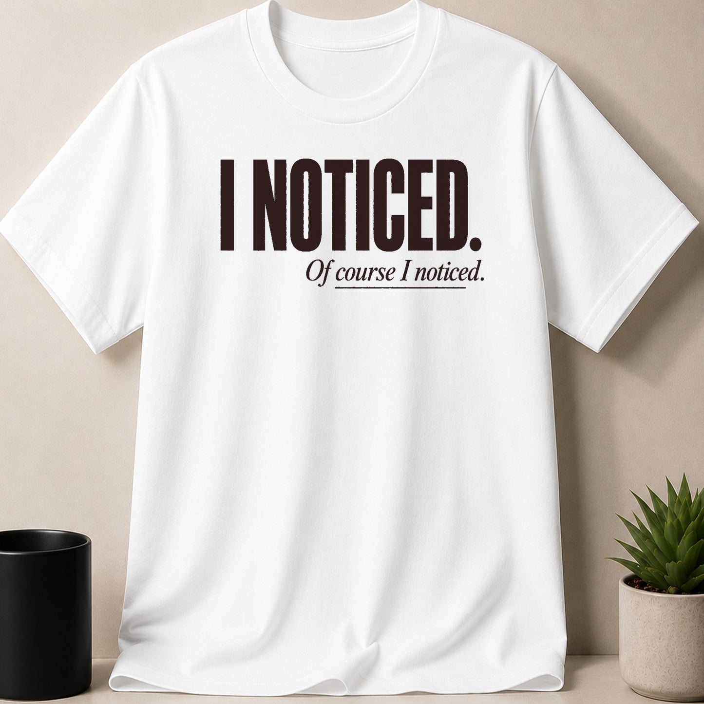 White t-shirt with dark text "I NOTICED. Of course I noticed."