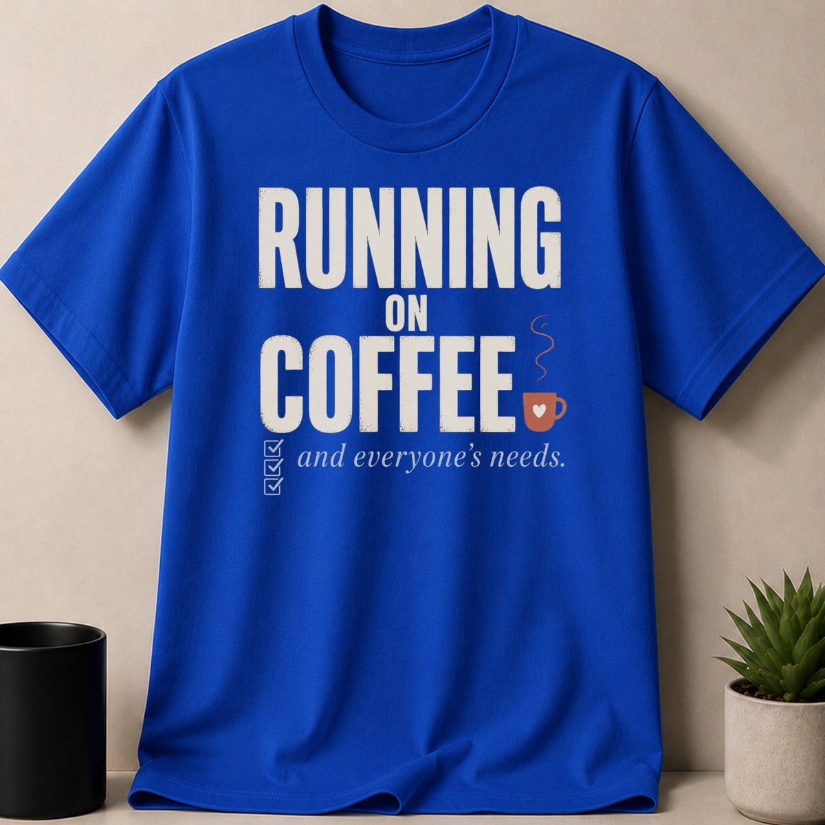 Blue t-shirt with text "RUNNING ON COFFEE and everyone's needs."