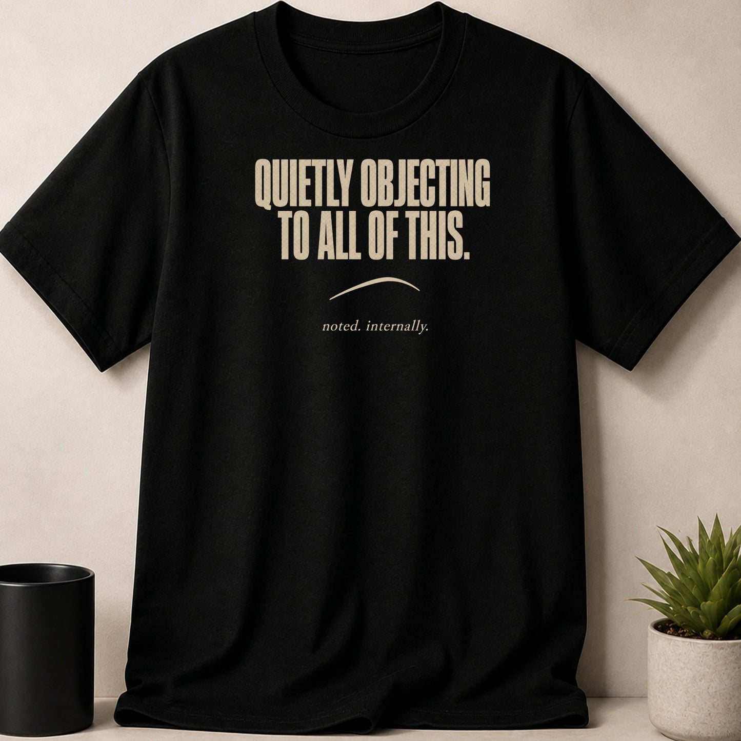 Black t-shirt with text "QUIETLY OBJECTING TO ALL OF THIS. noted. internally."