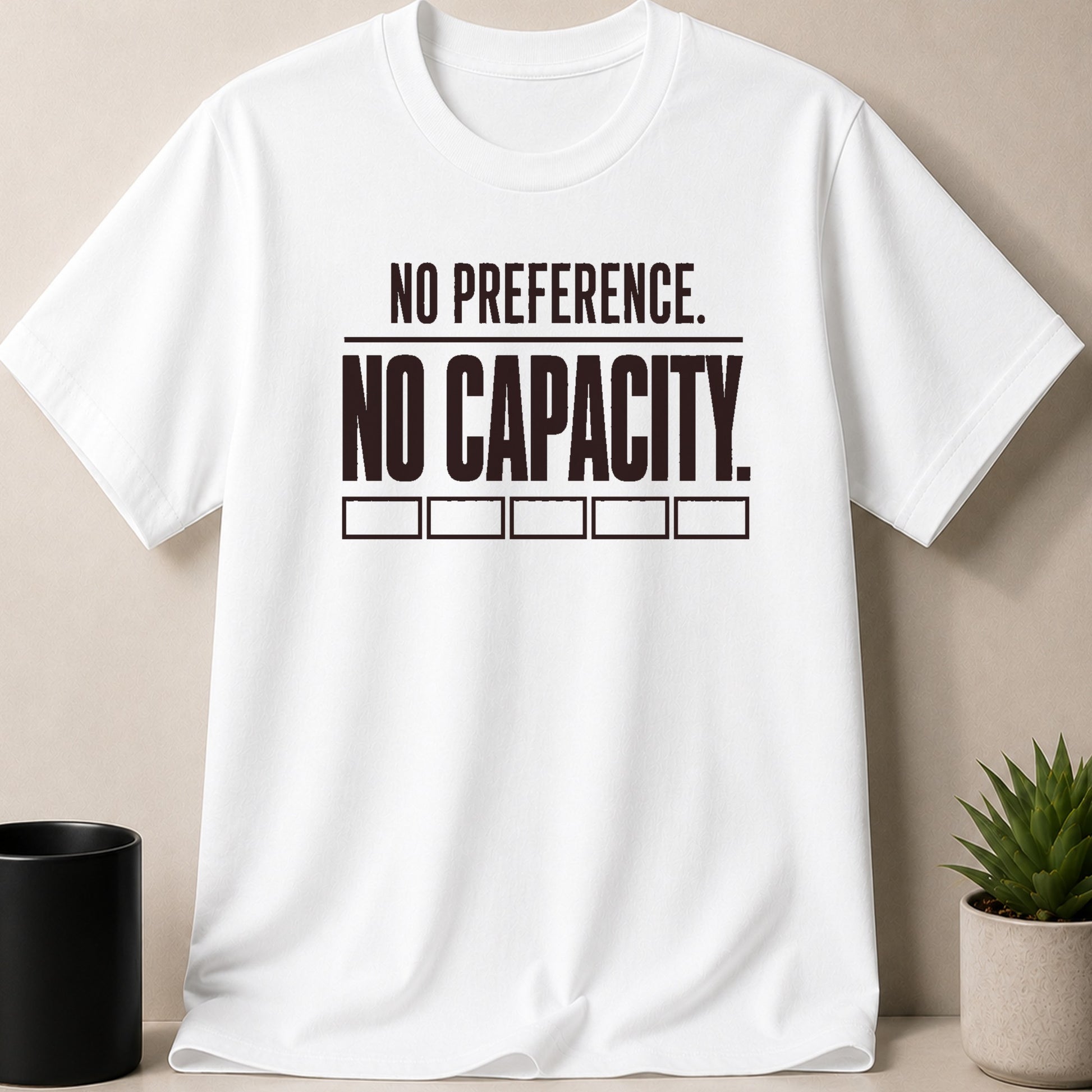 White t-shirt with black text reading "NO PREFERENCE. NO CAPACITY."