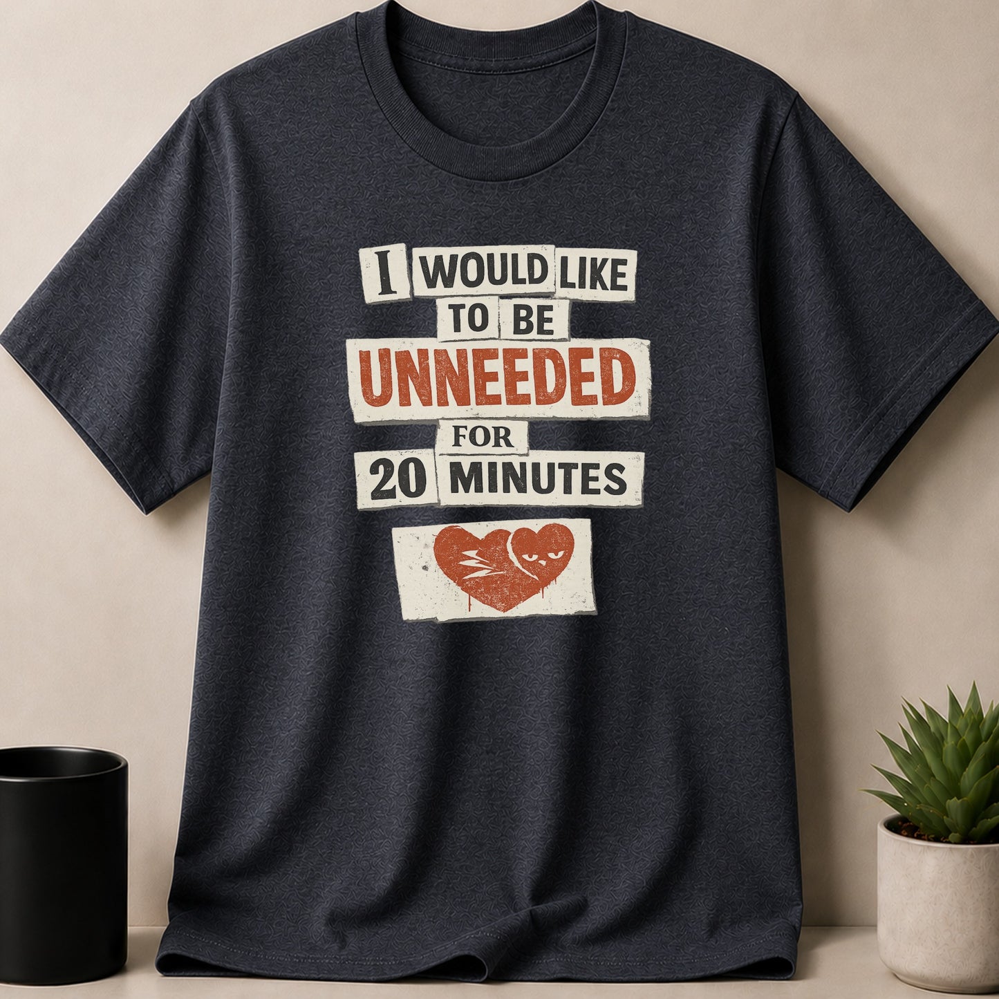 Dark t-shirt with text "I WOULD LIKE TO BE UNNEEDED FOR 20 MINUTES" and a broken heart graphic.