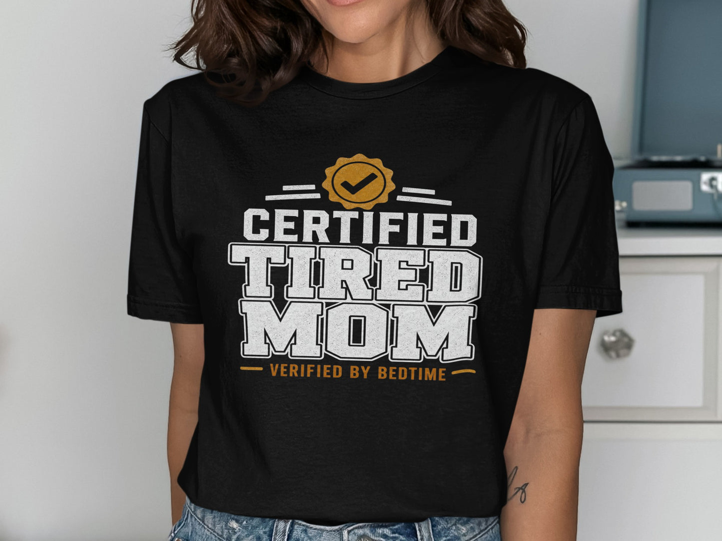 Black t-shirt with "Certified Tired Mom Verified by Bedtime" text.