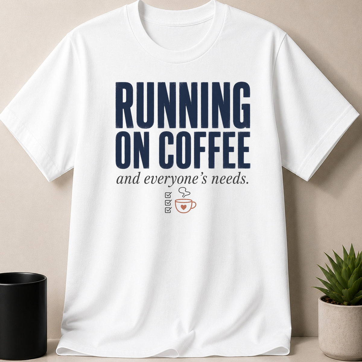 White t-shirt with navy text "RUNNING ON COFFEE and everyone's needs" and coffee cup graphic.