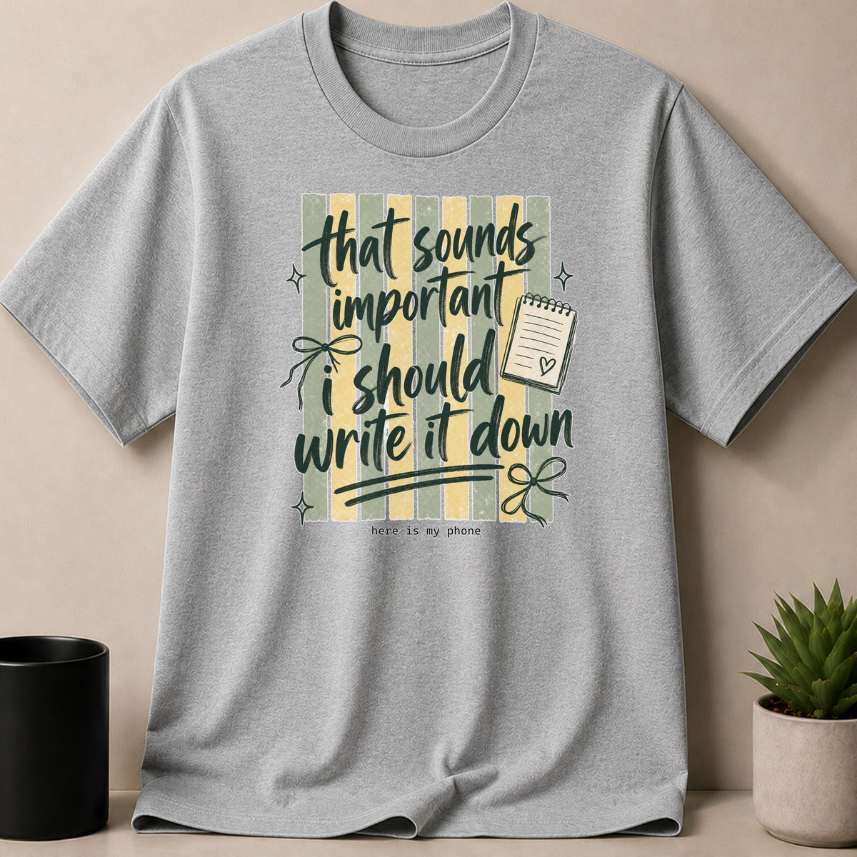 Grey t-shirt with green and yellow stripes and text that says "that sounds important i should write it down".