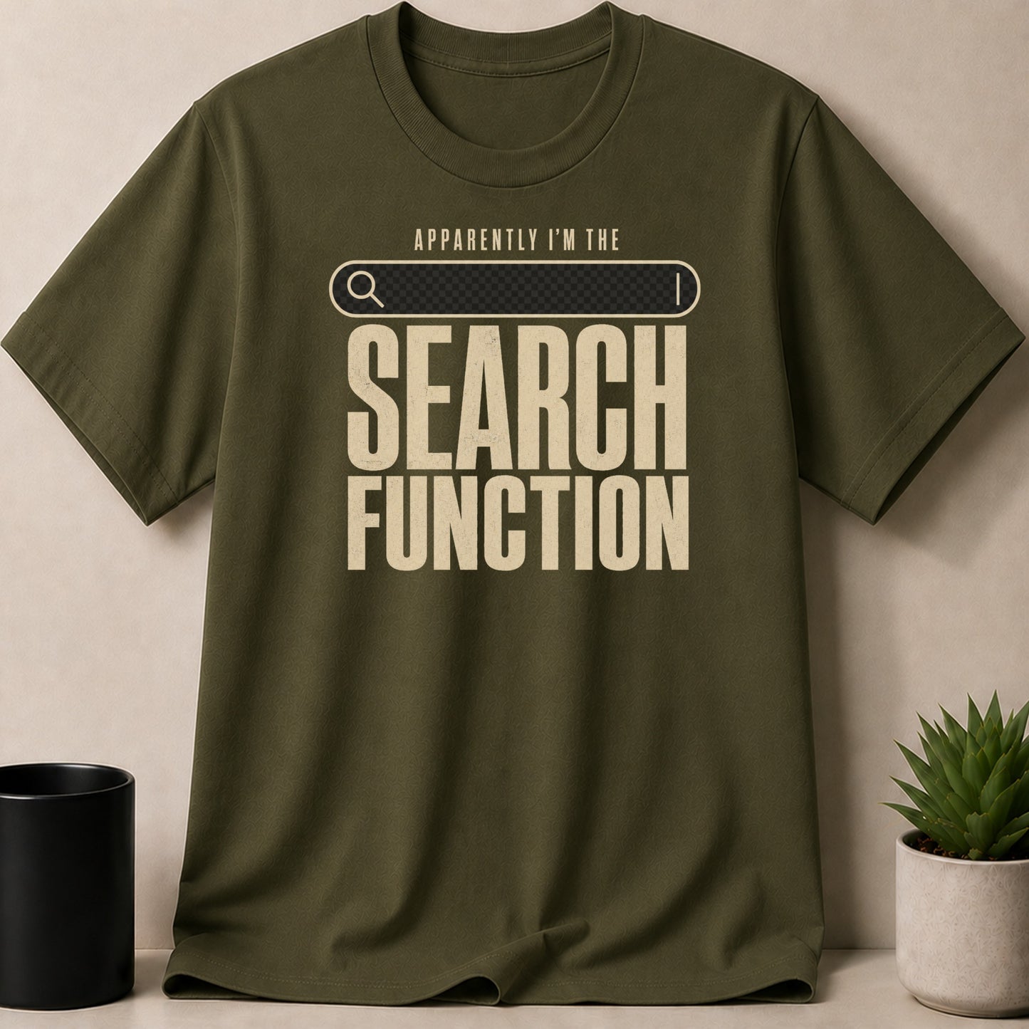 Green t-shirt with search bar graphic and text "APPARENTLY I'M THE SEARCH FUNCTION".