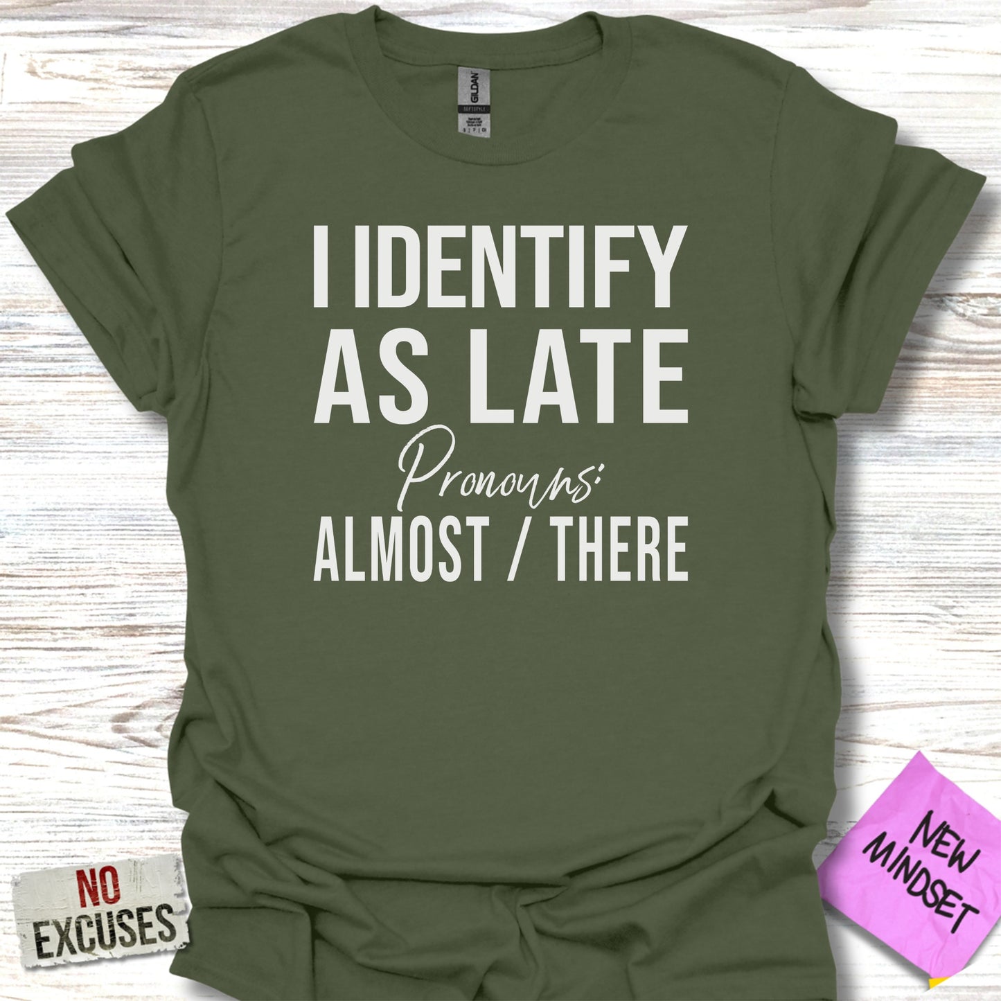 Green t-shirt with text "I identify as late. Pronouns: Almost / There."