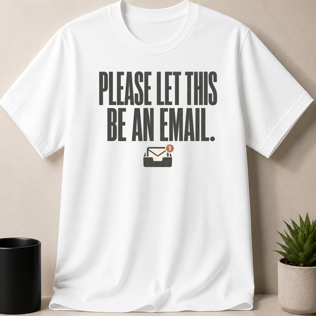 White t-shirt with distressed text "PLEASE LET THIS BE AN EMAIL." and an email icon.