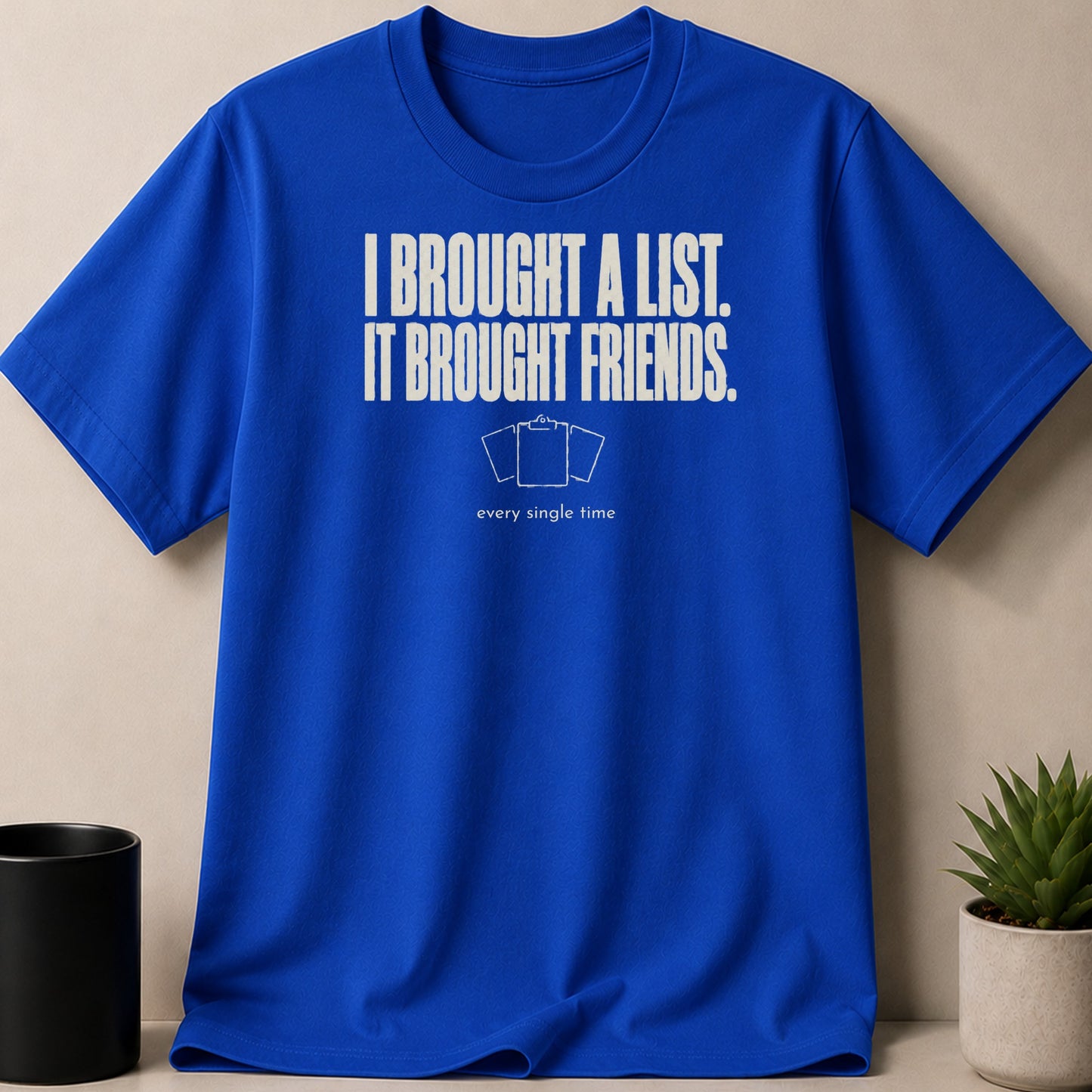 Blue t-shirt with white text "I BROUGHT A LIST. IT BROUGHT FRIENDS."