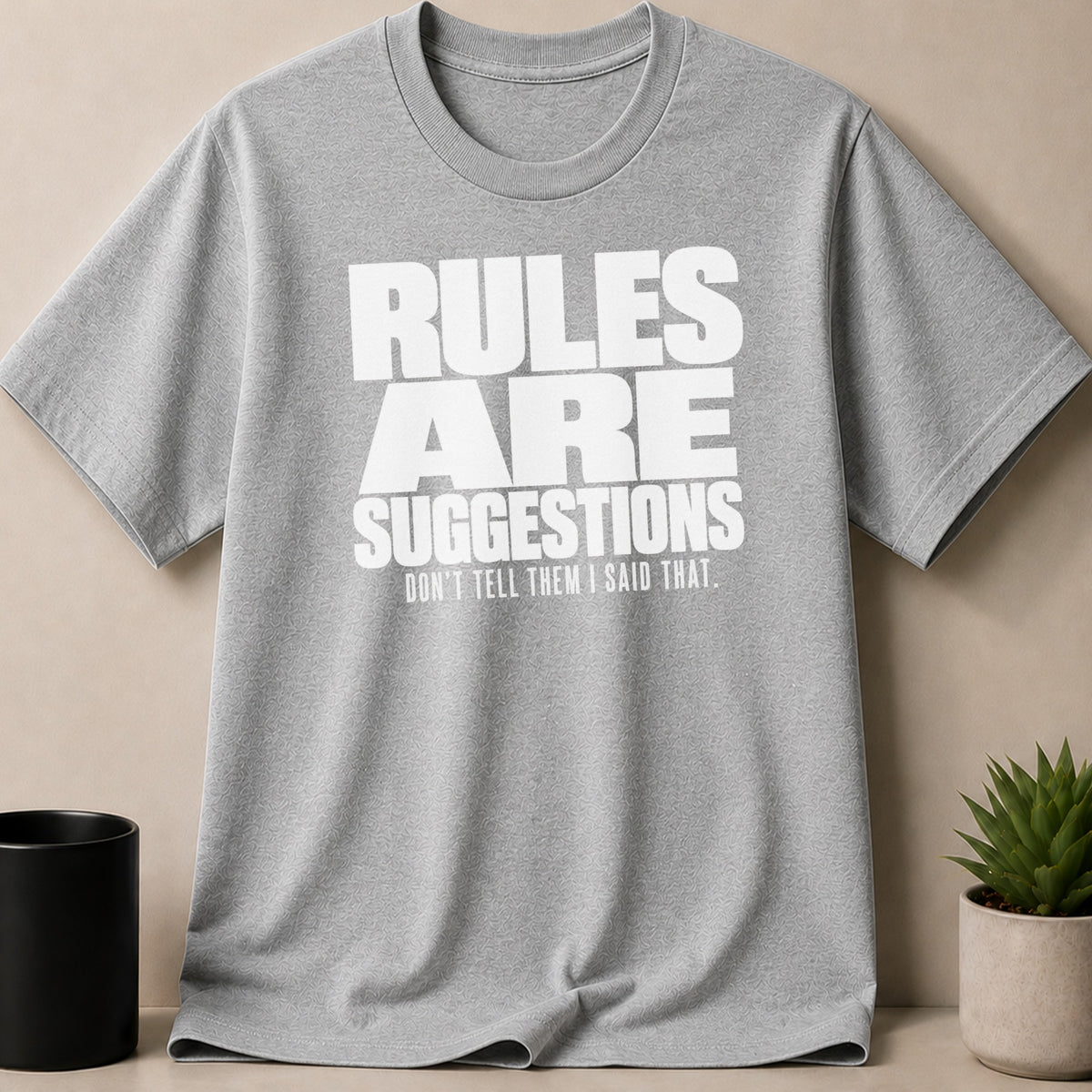 Gray t-shirt with white text reading "RULES ARE SUGGESTIONS. DON'T TELL THEM I SAID THAT."