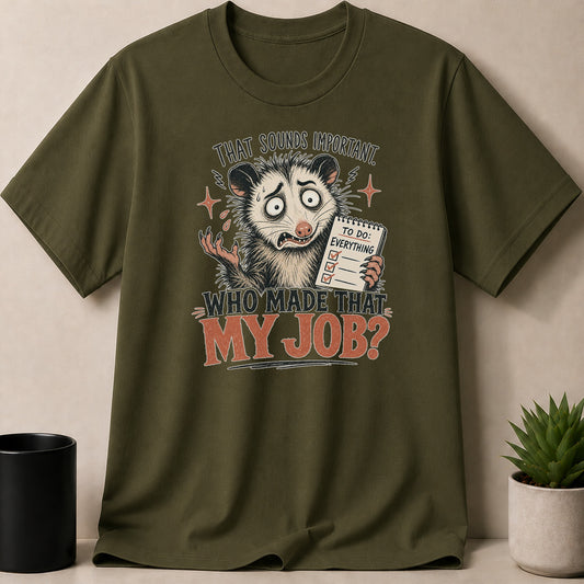Green t-shirt with opossum graphic saying "That sounds important. Who made that my job?"