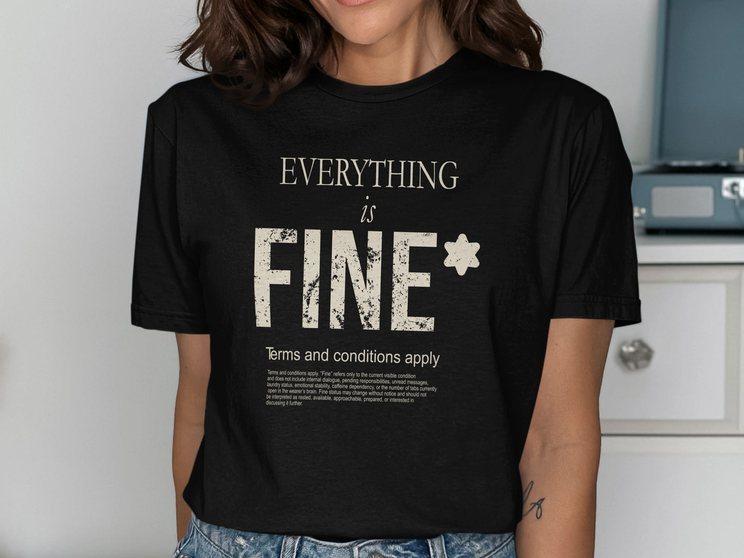 Black t-shirt with "EVERYTHING is FINE*" and text.