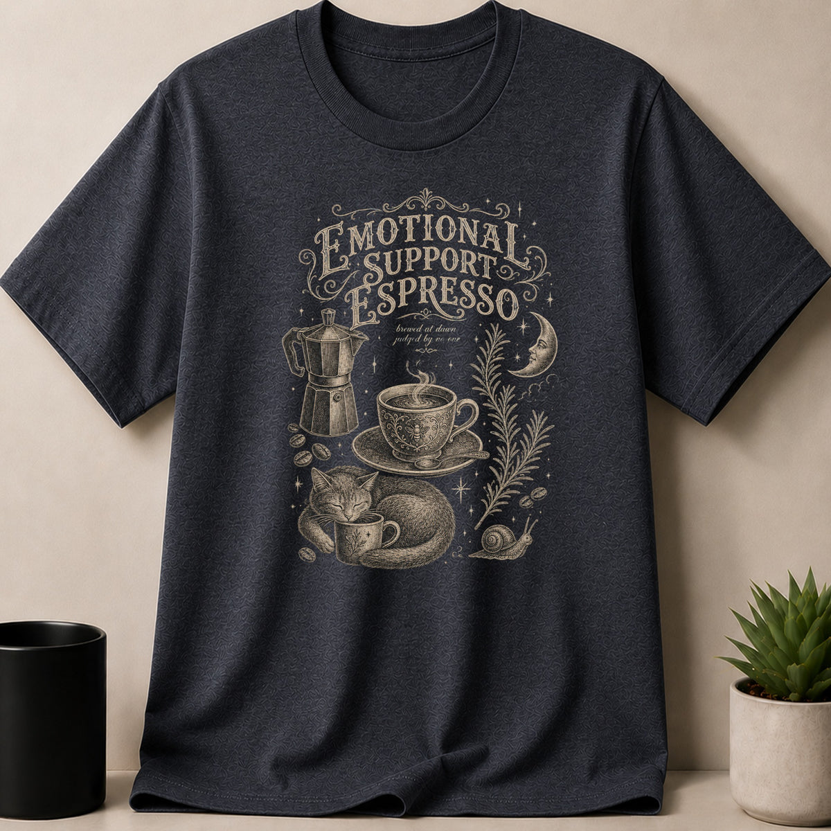 Dark t-shirt displaying 'Emotional Support Espresso' with a cat, coffee, and celestial elements.