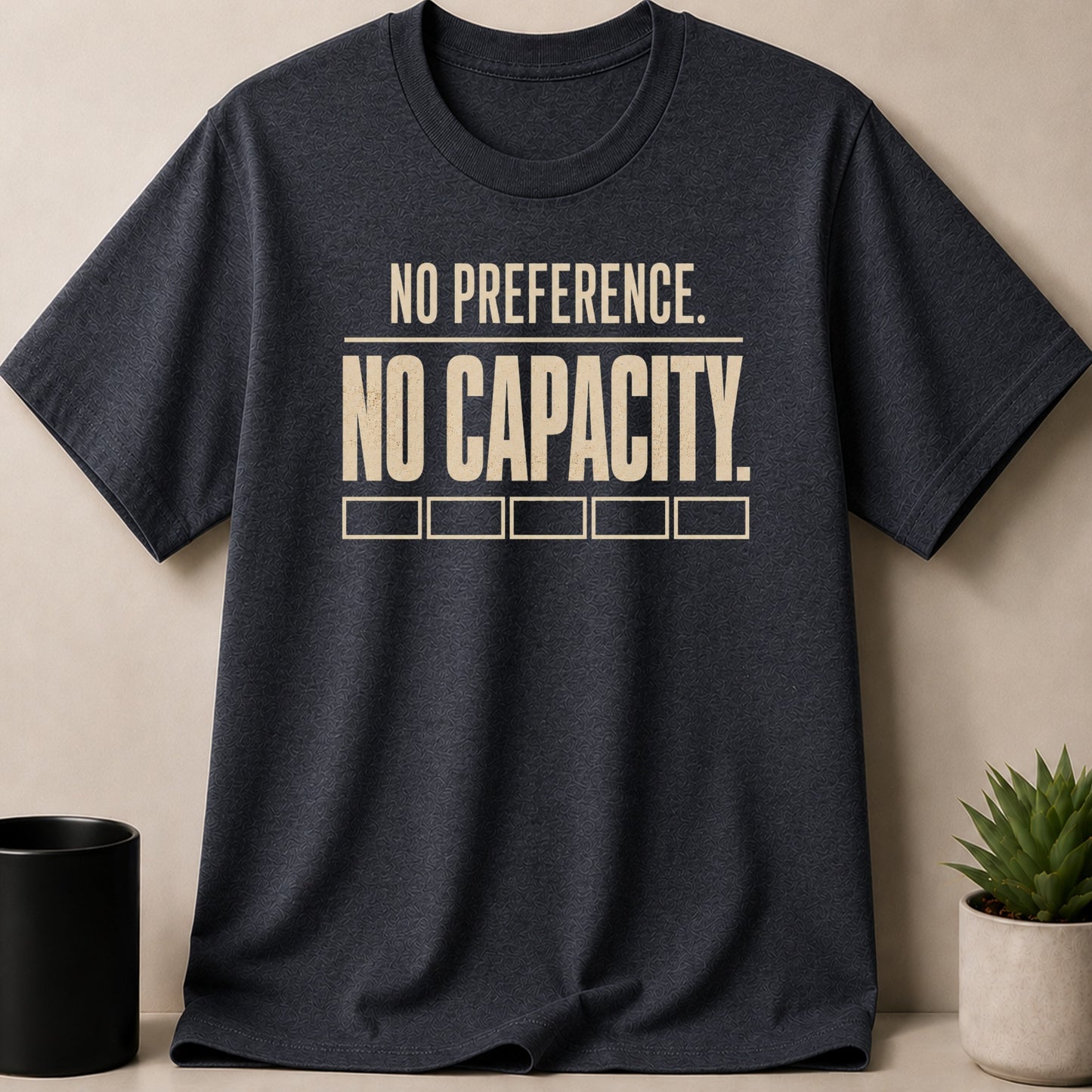 Dark grey t-shirt with "NO PREFERENCE. NO CAPACITY." text and empty squares.