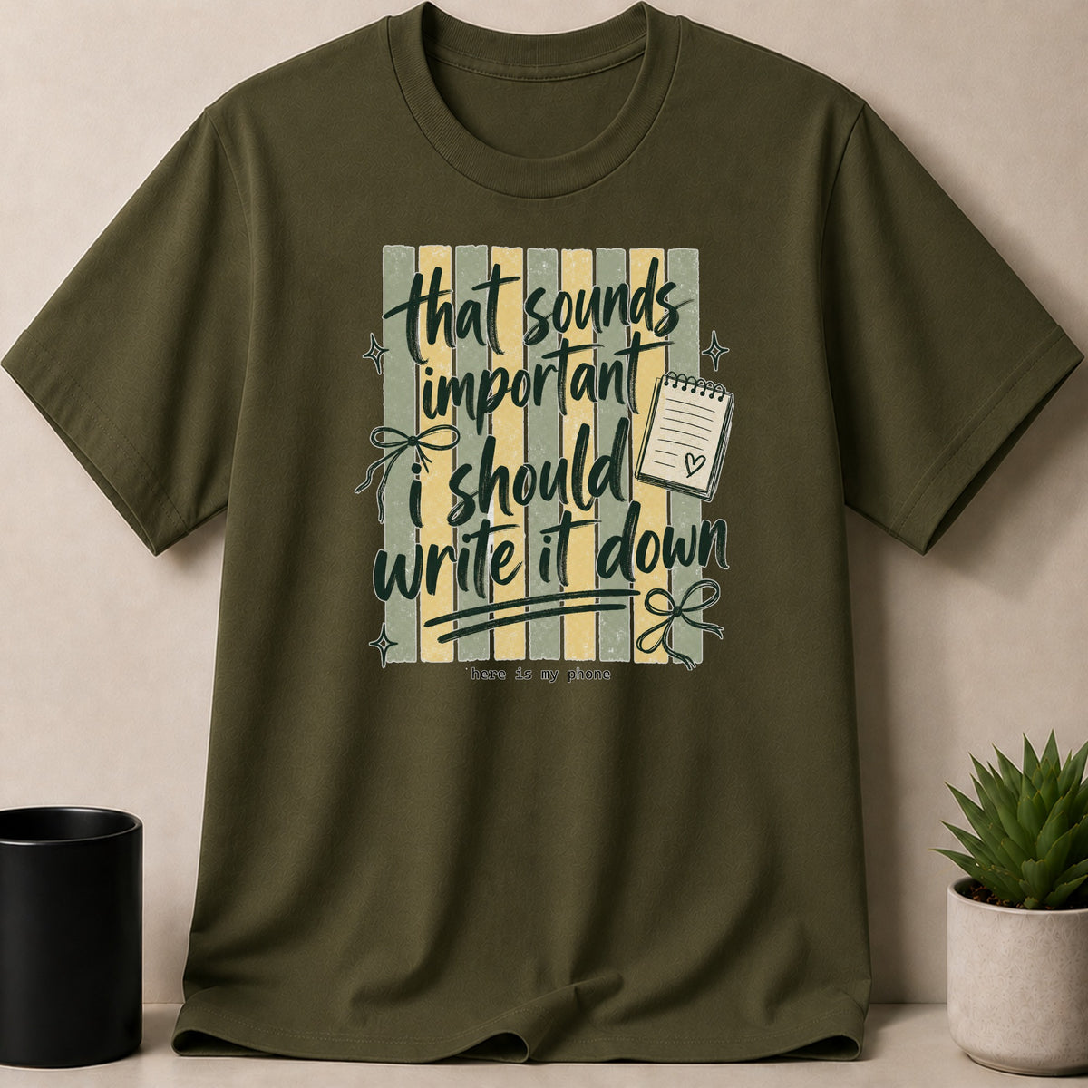 Olive green t-shirt with "that sounds important i should write it down" text and a notepad.