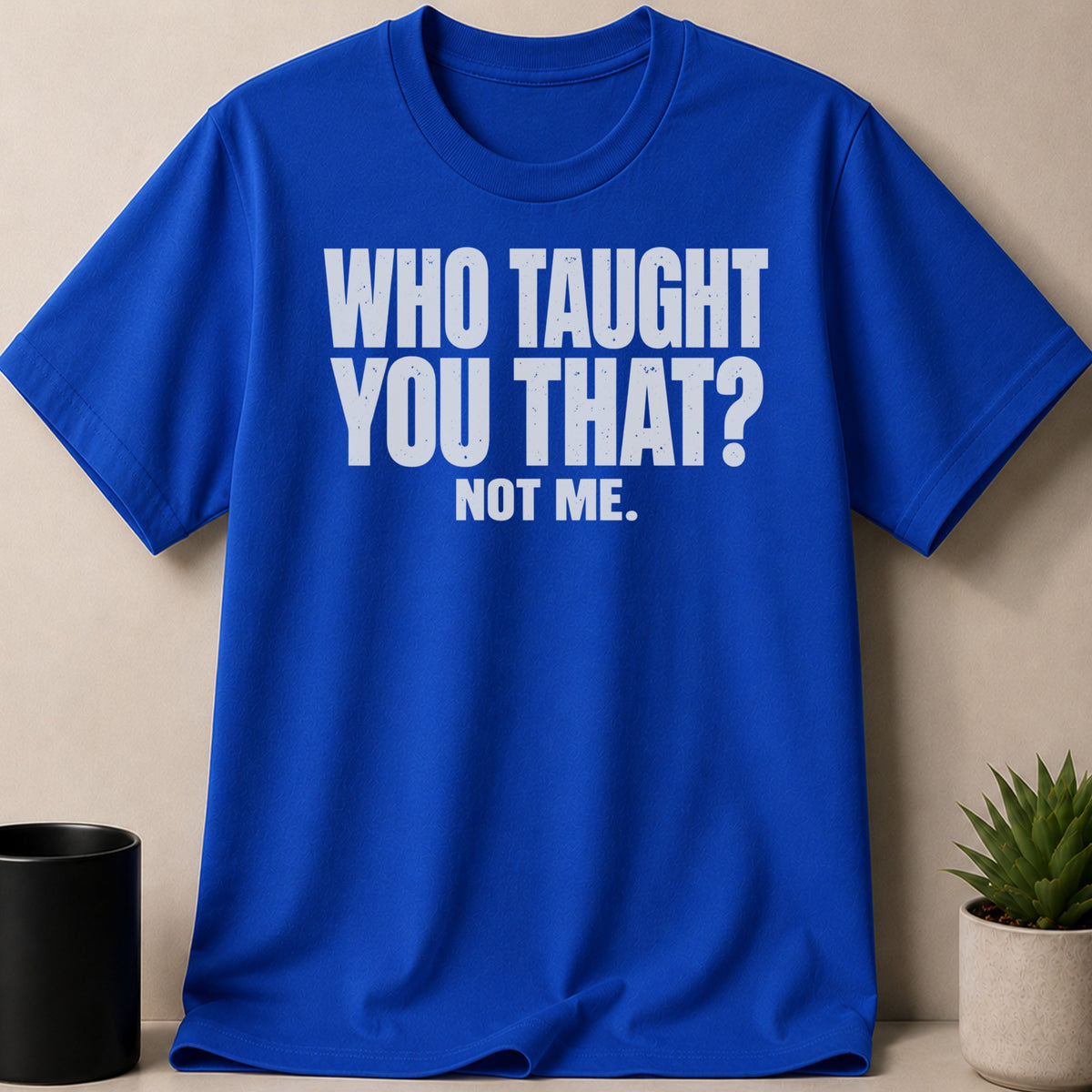 Royal blue crewneck t-shirt featuring the white distressed text WHO TAUGHT YOU THAT? NOT ME.