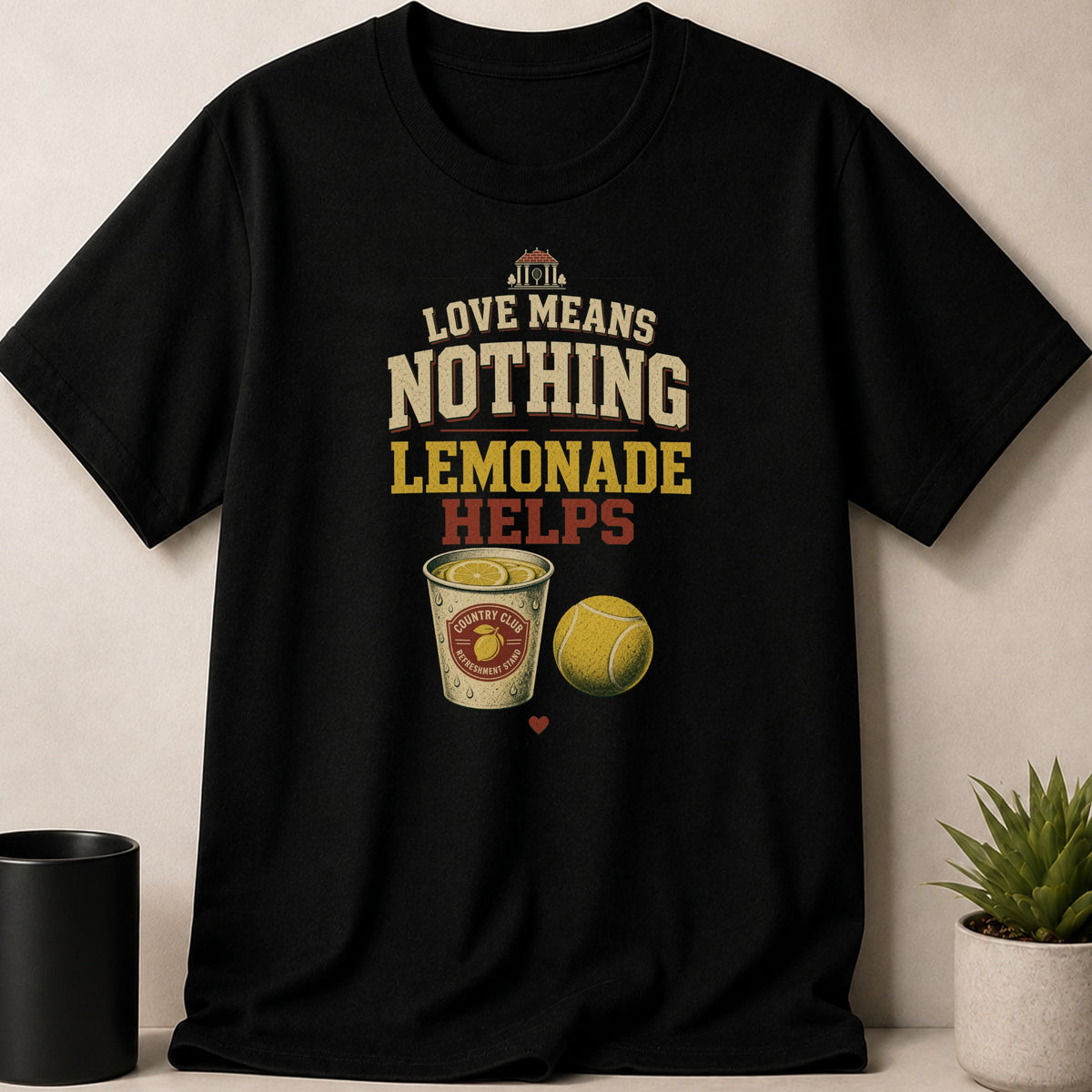 Black t-shirt with "Love Means Nothing Lemonade Helps" text, lemonade, and tennis ball.