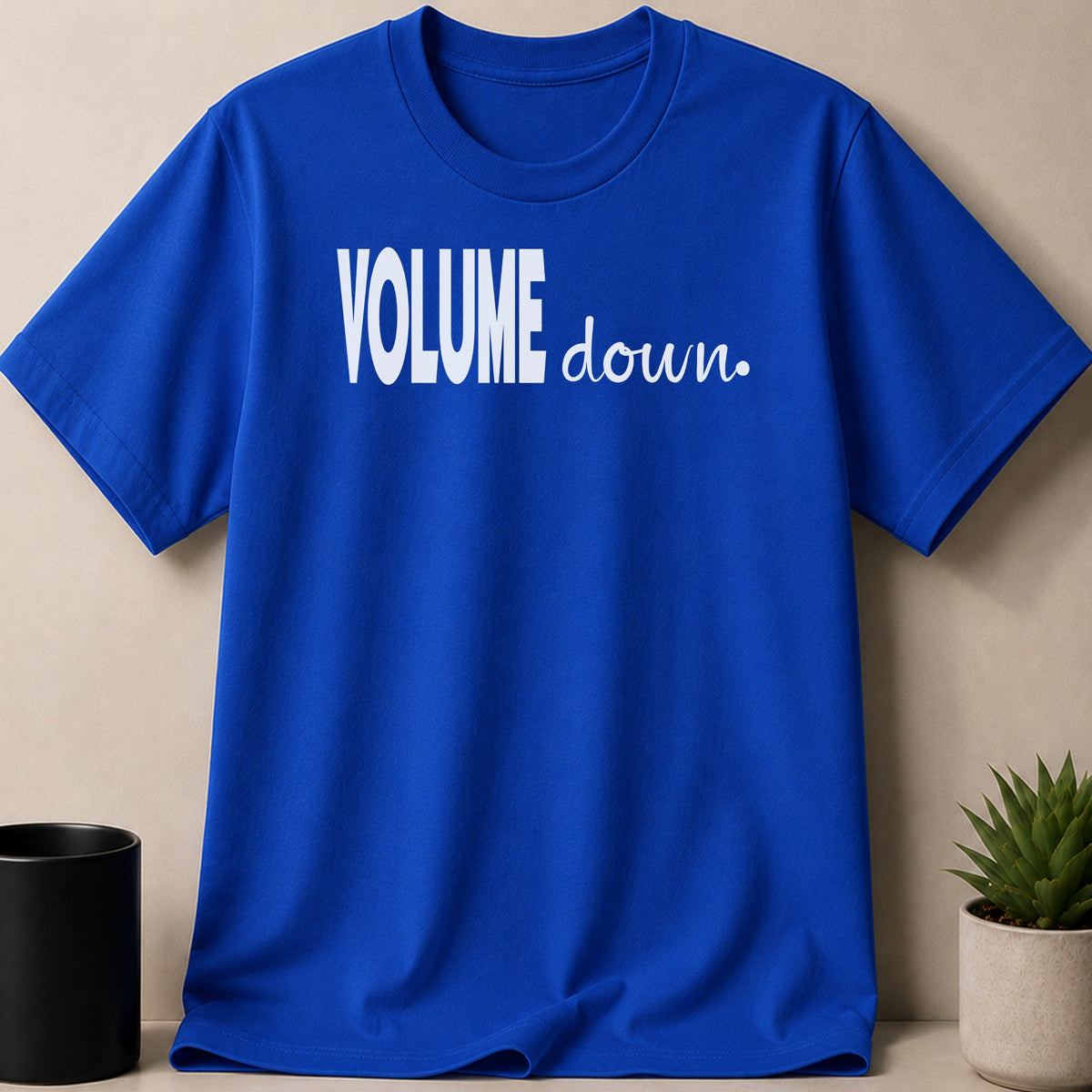 Blue t-shirt with white text that says "VOLUME down."
